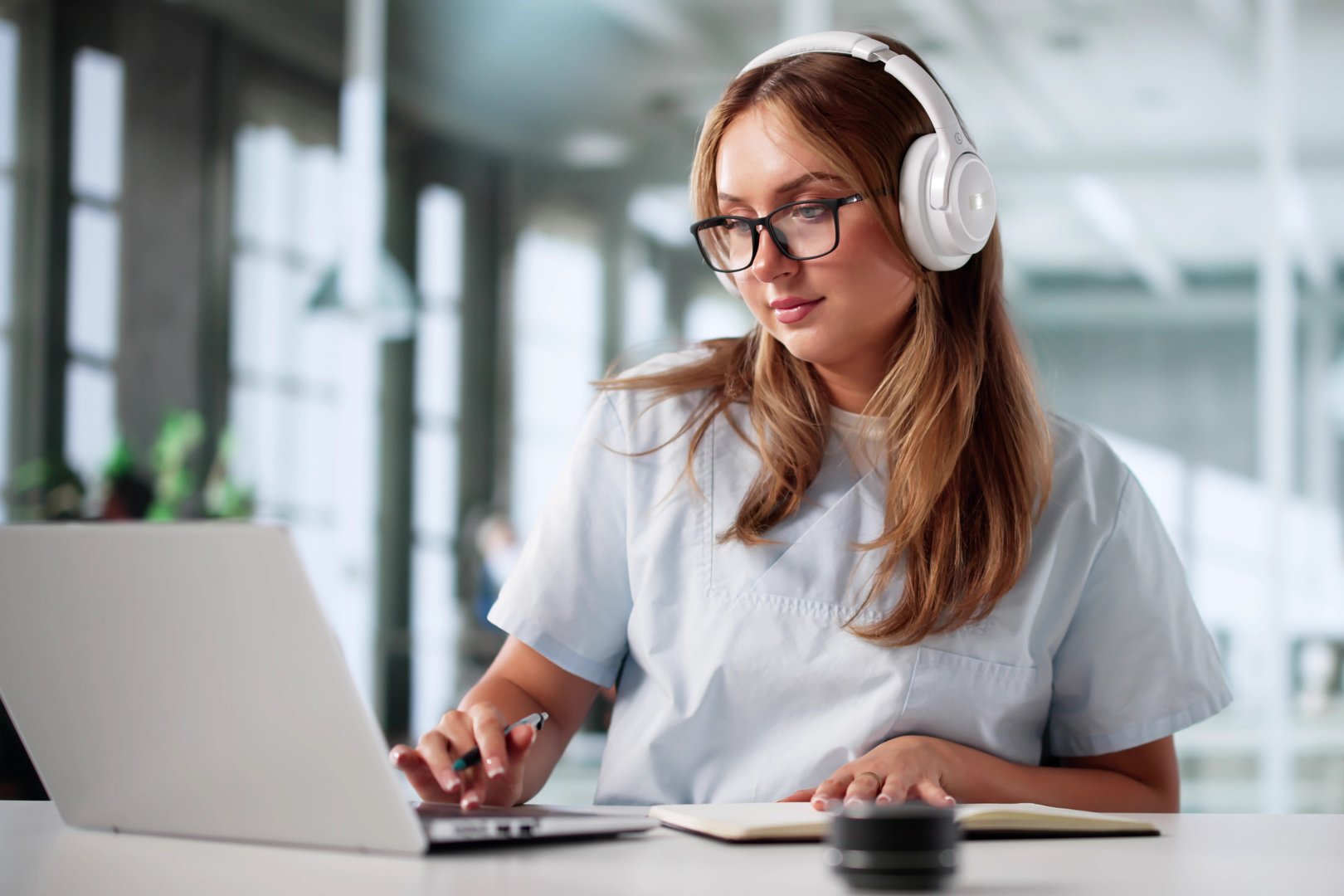 Medical Student Learning In Online Remote Webinar On Laptop With Headphones