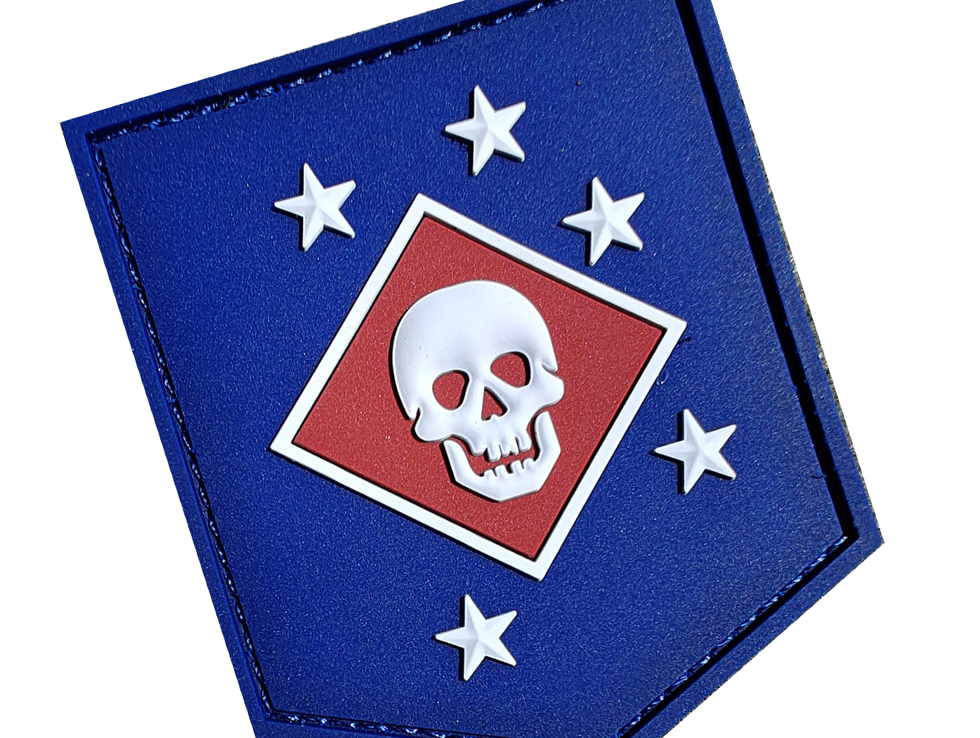 Shield-shaped patch with white skull on red background, surrounded by five white stars on a blue field.