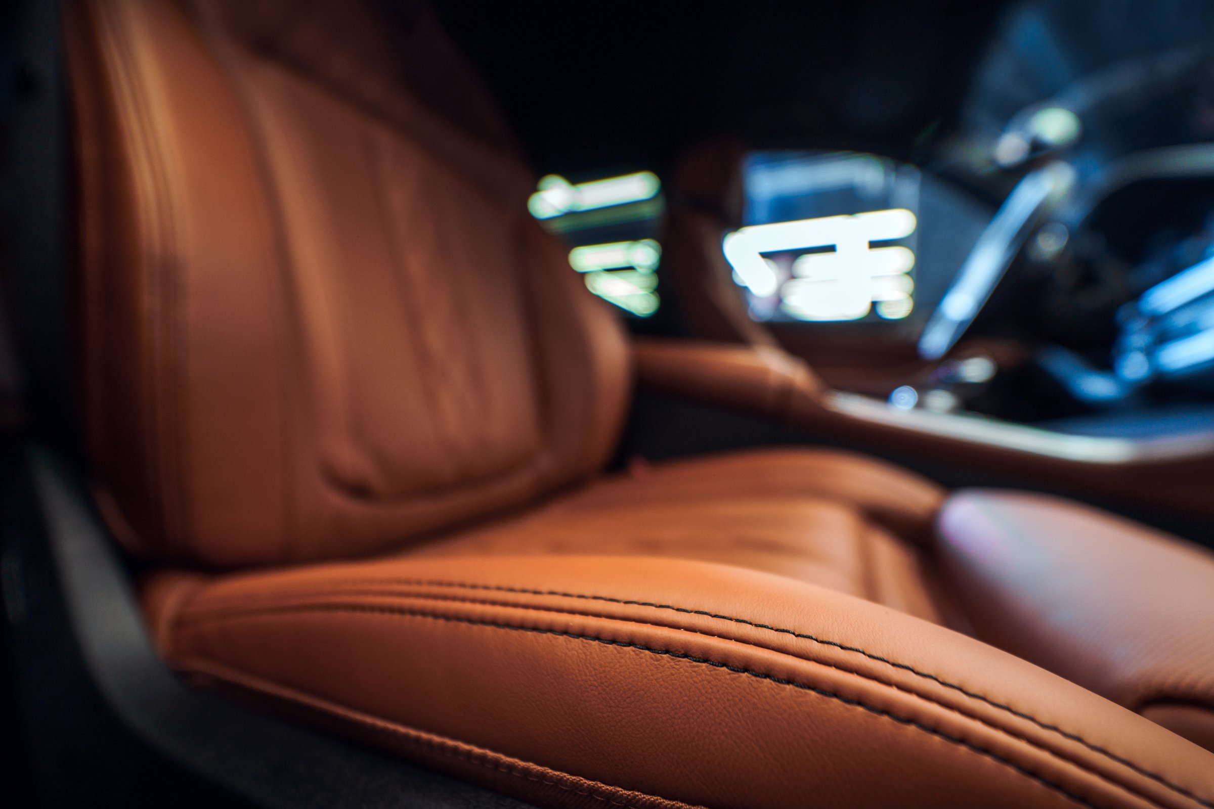 Close-up of a high-quality leather car seat, showcasing the luxurious texture and detailed stitching in a premium vehicle interior