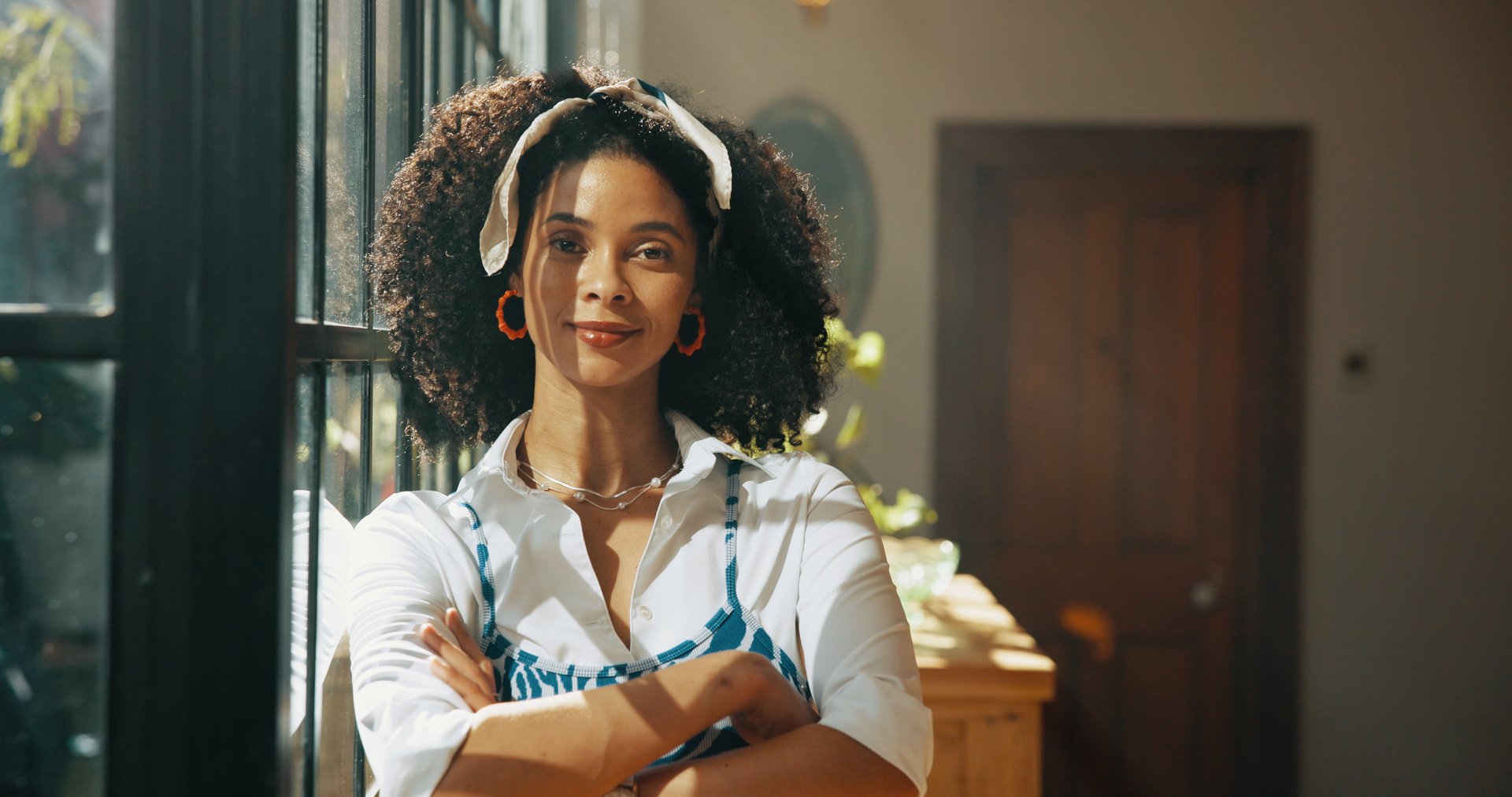 Portrait, African woman and arms crossed pride at house for morning start, weekend break and peace in property. Female person, confident and fashion of cozy afternoon, natural afro and stylish outfit