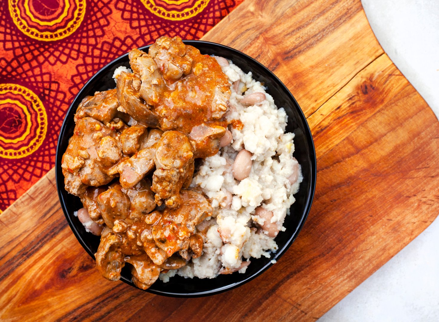 Traditional South African Peri Peri chicken livers with samp and beans on traditional South African fabric