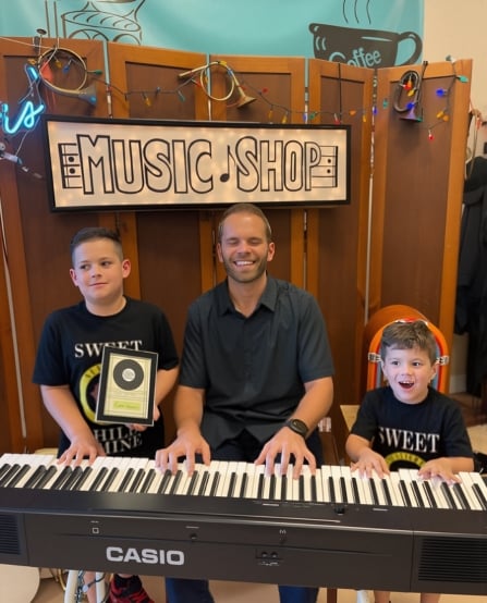 Music teacher teaching group of children in classroom