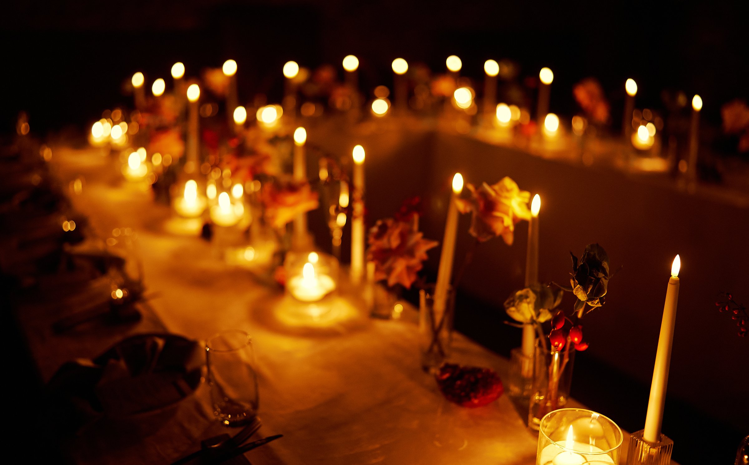 Elegant candlelit dining setup with flowers creating a romantic atmosphere during an evening gathering