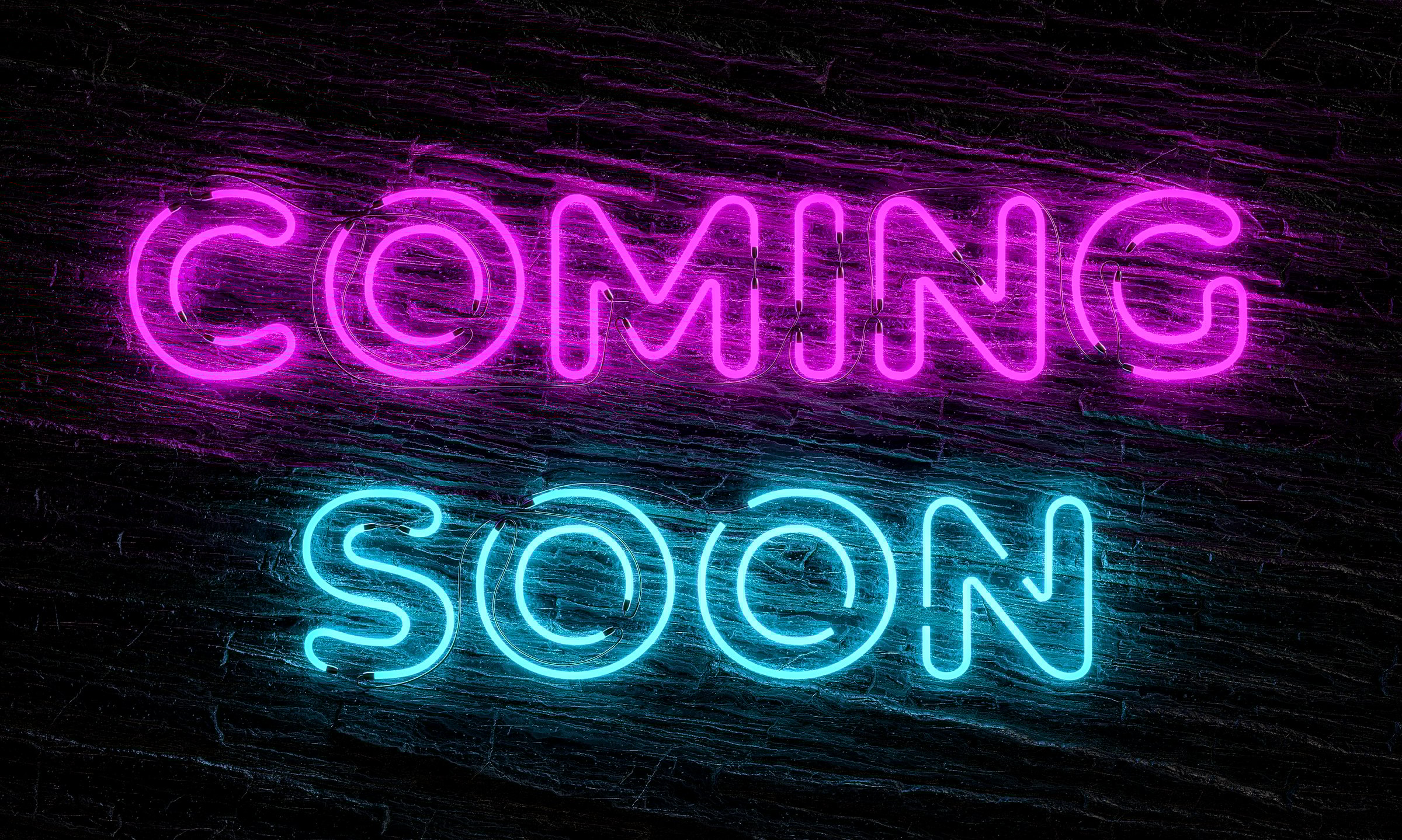 Vibrant neon sign displaying coming soon against a dark wooden background