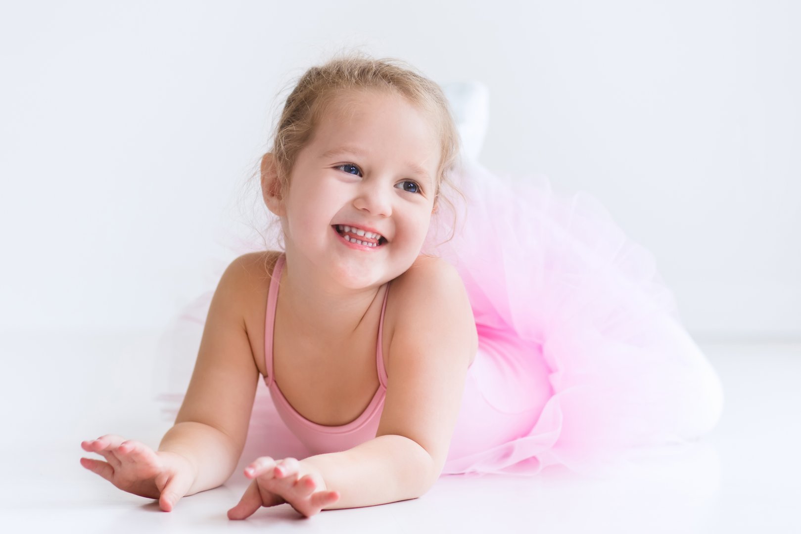 Little ballerina girl in a pink tutu. Adorable child dancing classical ballet in a white studio. Children dance. Kids performing. Young gifted dancer in a class. Preschool kid taking art lessons.