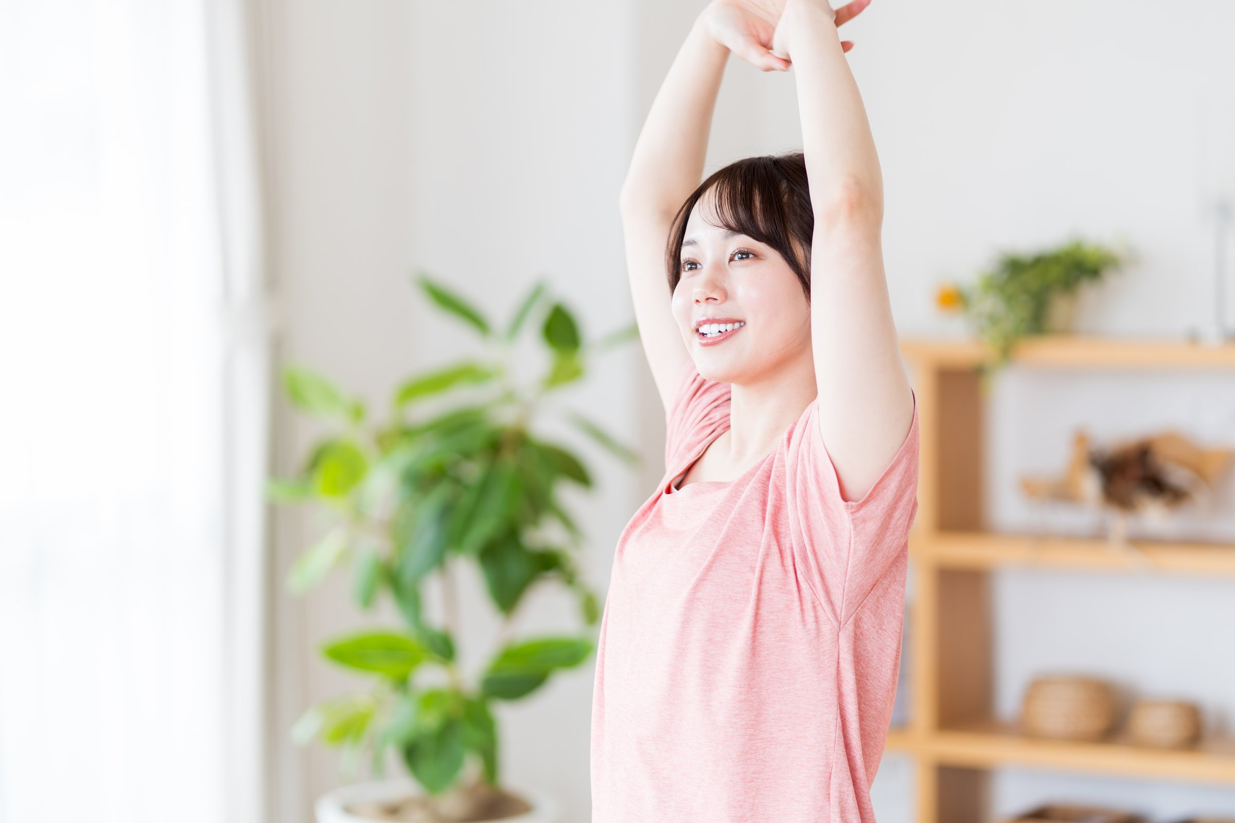 A young woman stretching in the living room.