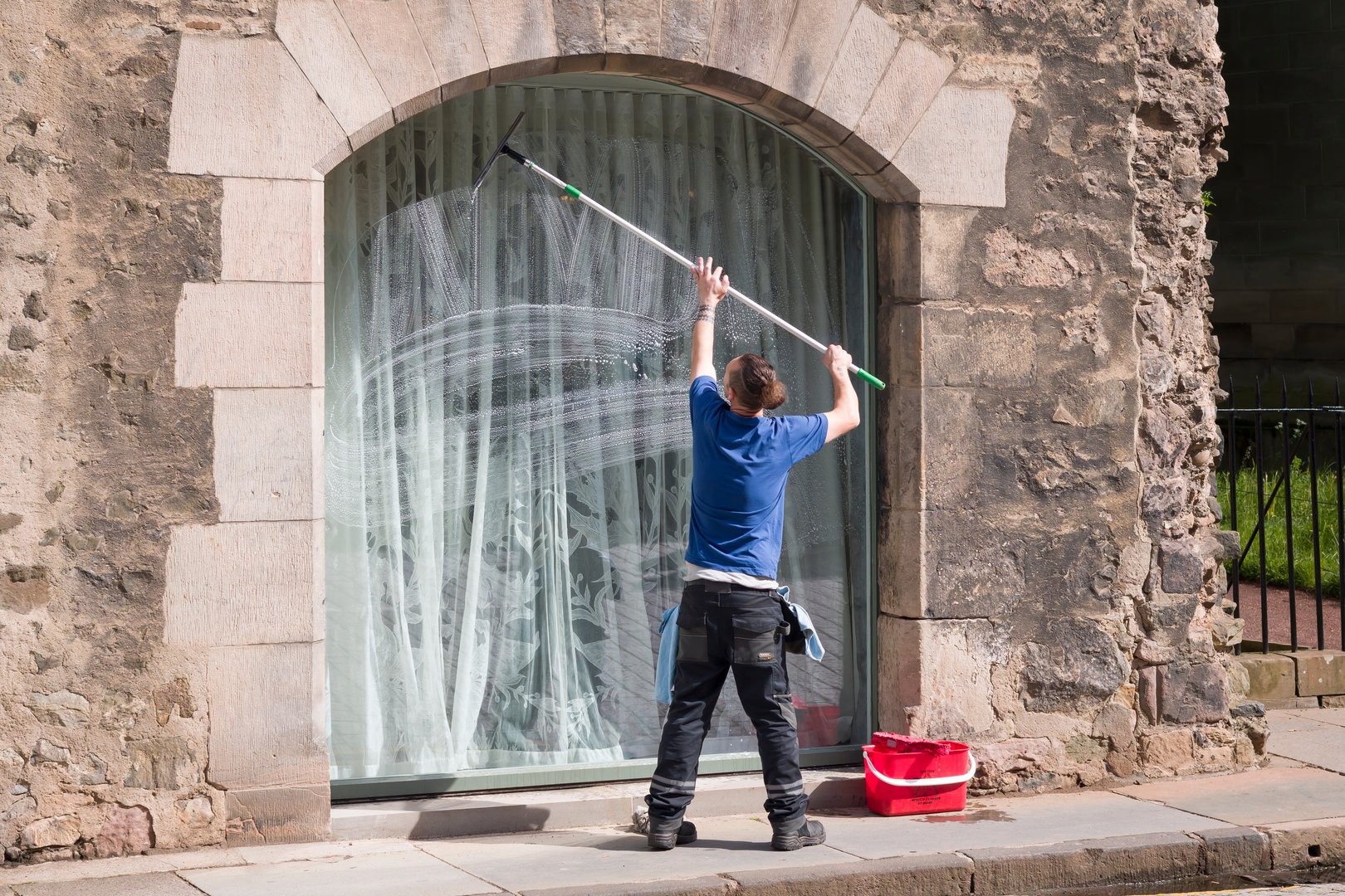 Edinburgh, UK - May 30, 2024. Window cleaner cleaning a window of a historic building in Edinburgh, Scotland, UK