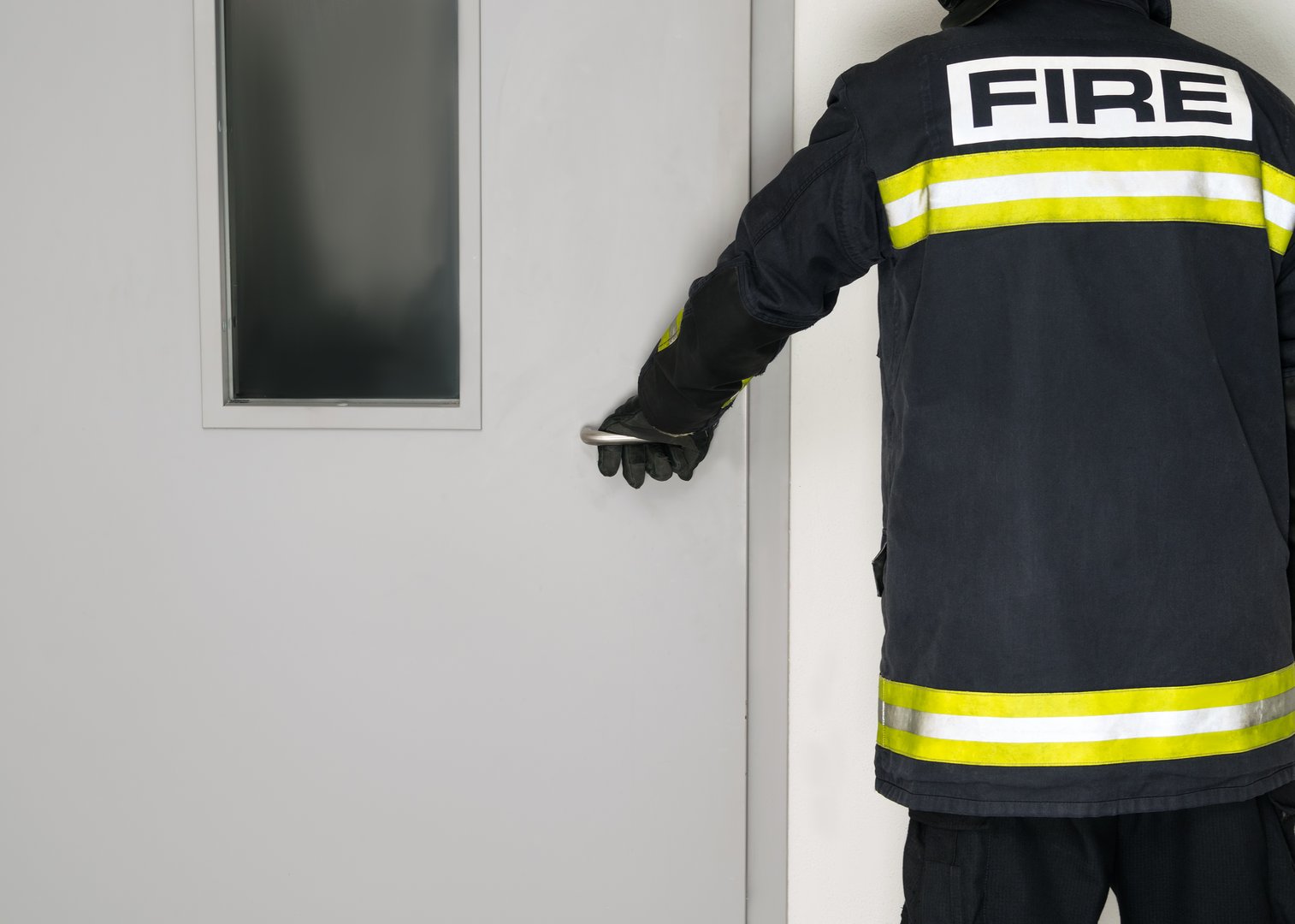 a man in a fireman's uniform opens the door, rear view