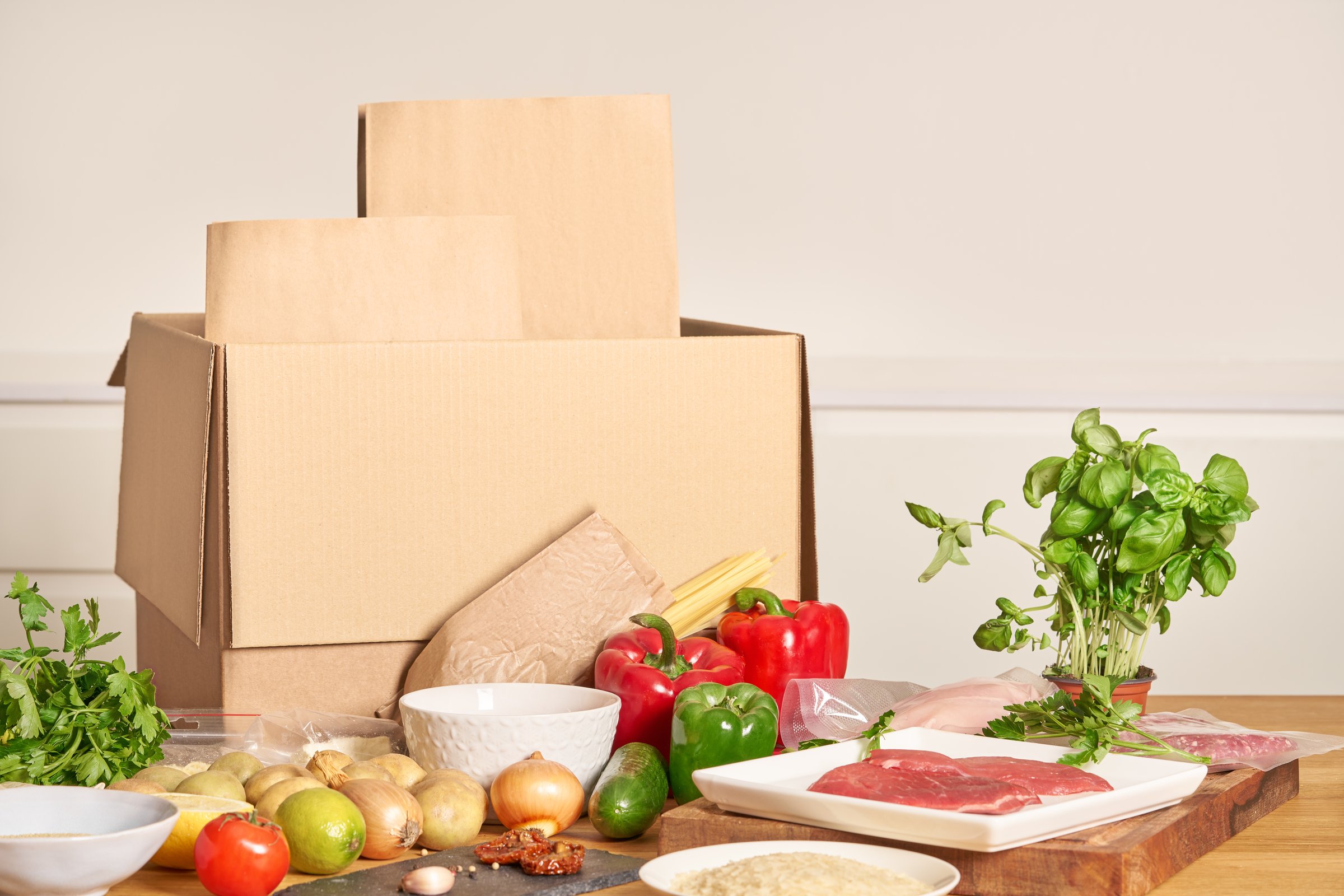 Box with packed meat vegetables on kitchen background. Food delivery services during coronavirus pandemic and social distancing. Shopping online. Dinner delivery service.
