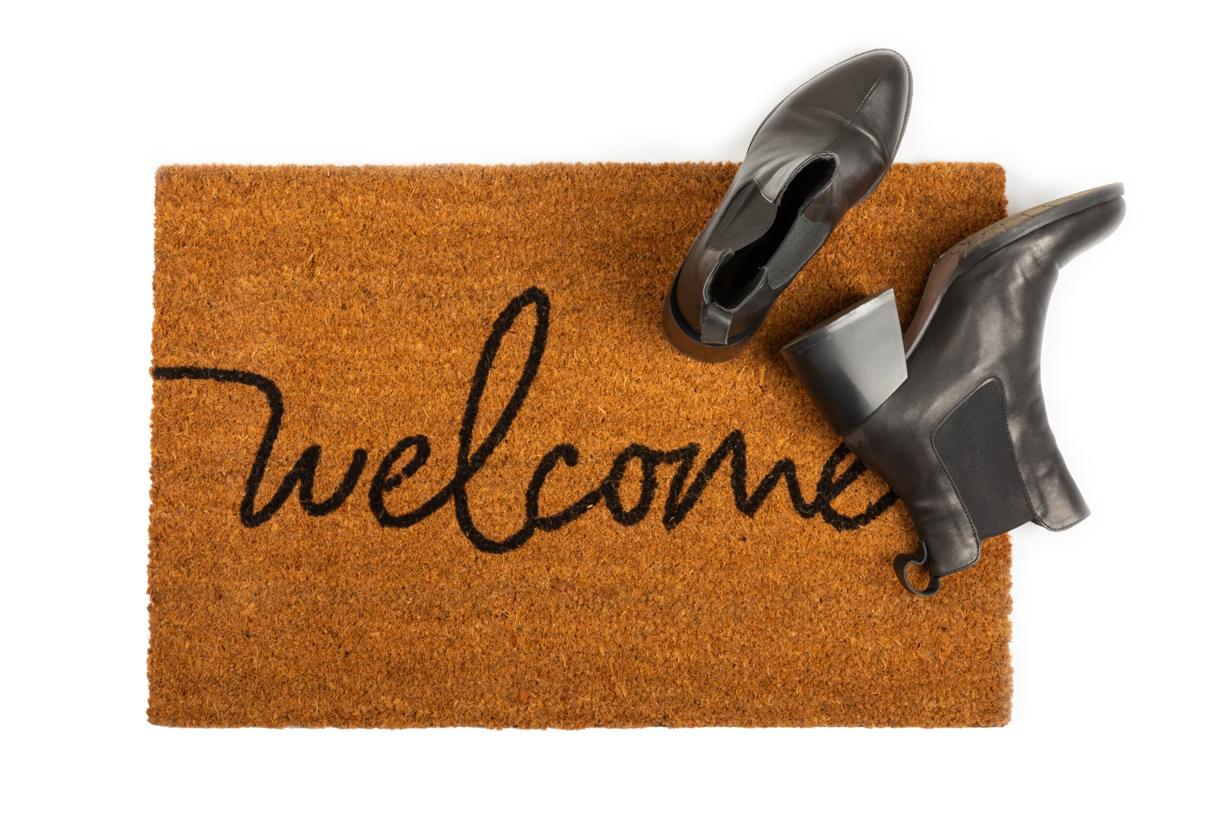 Door mat. Welcome mat isolated on white background. Women's shoes on a doormat on a white background. Interior decor element in the hallway. Close-up.
