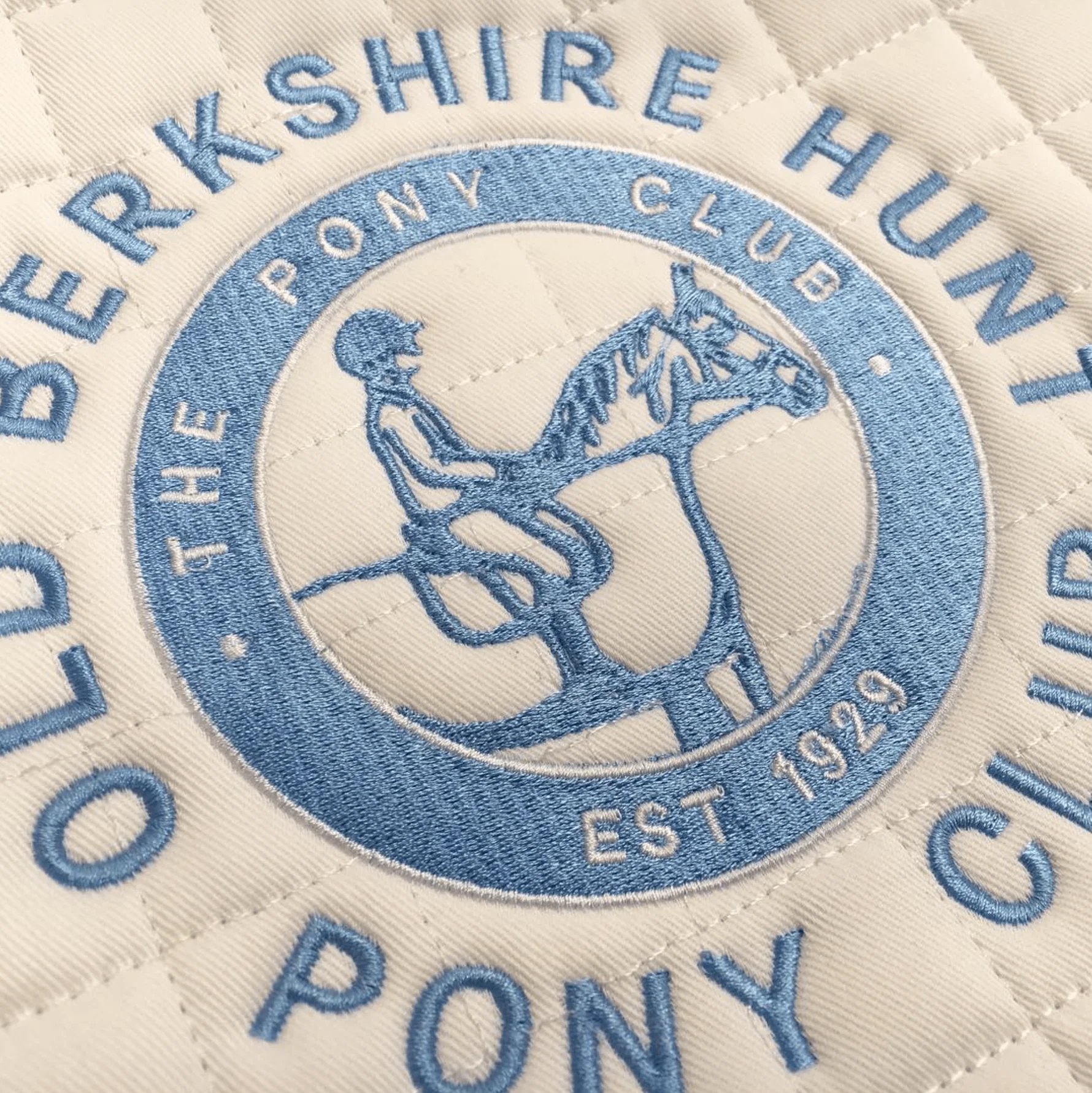 Embroidered crest of Old Berkshire Hunt Pony Club featuring a rider on a horse, established 1929, in blue and white.