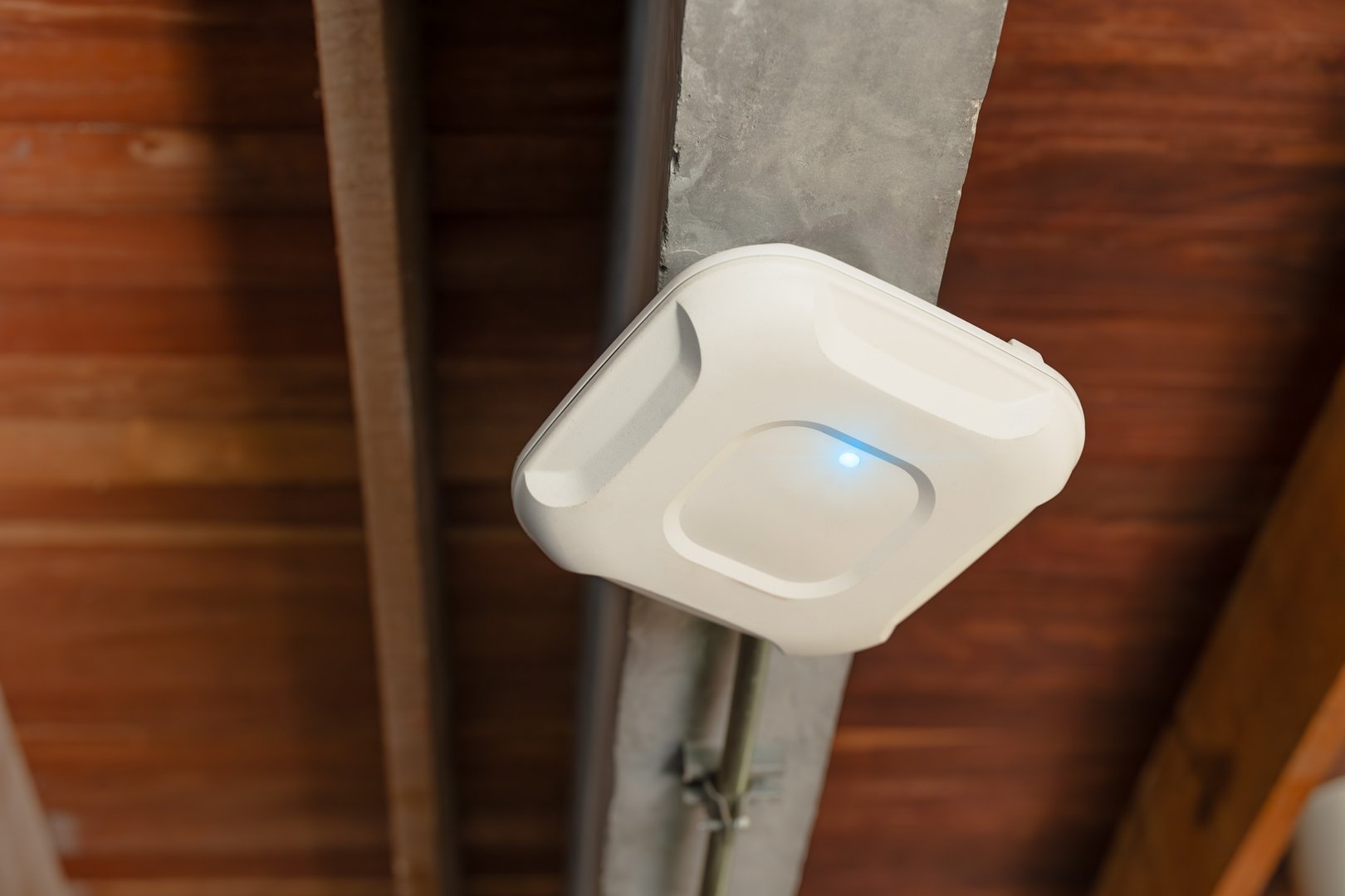 Wireless router for internet local network at ceiling. Indoor networking technology. WIFI router or Wireless Access Point setup at ceiling for Internet connection office space or cafe.