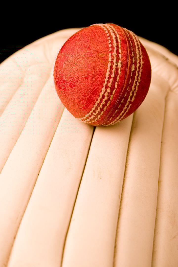 Worn red leather Cricket Ball and pads