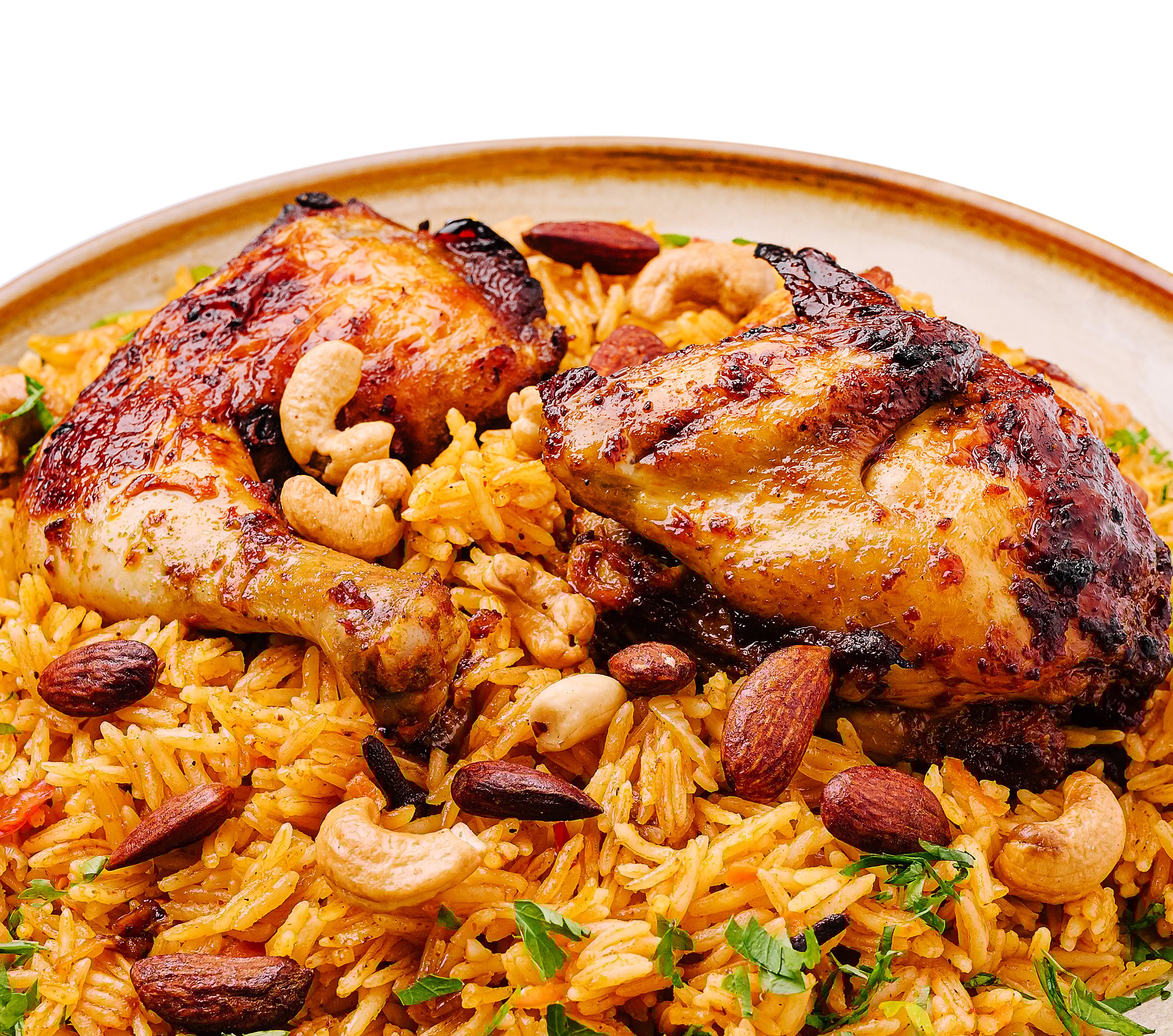 Juicy grilled chicken pieces rest on a bed of flavorful spiced rice, adorned with almonds, cashews, and fresh herbs. This delightful meal offers a blend of tastes and textures.