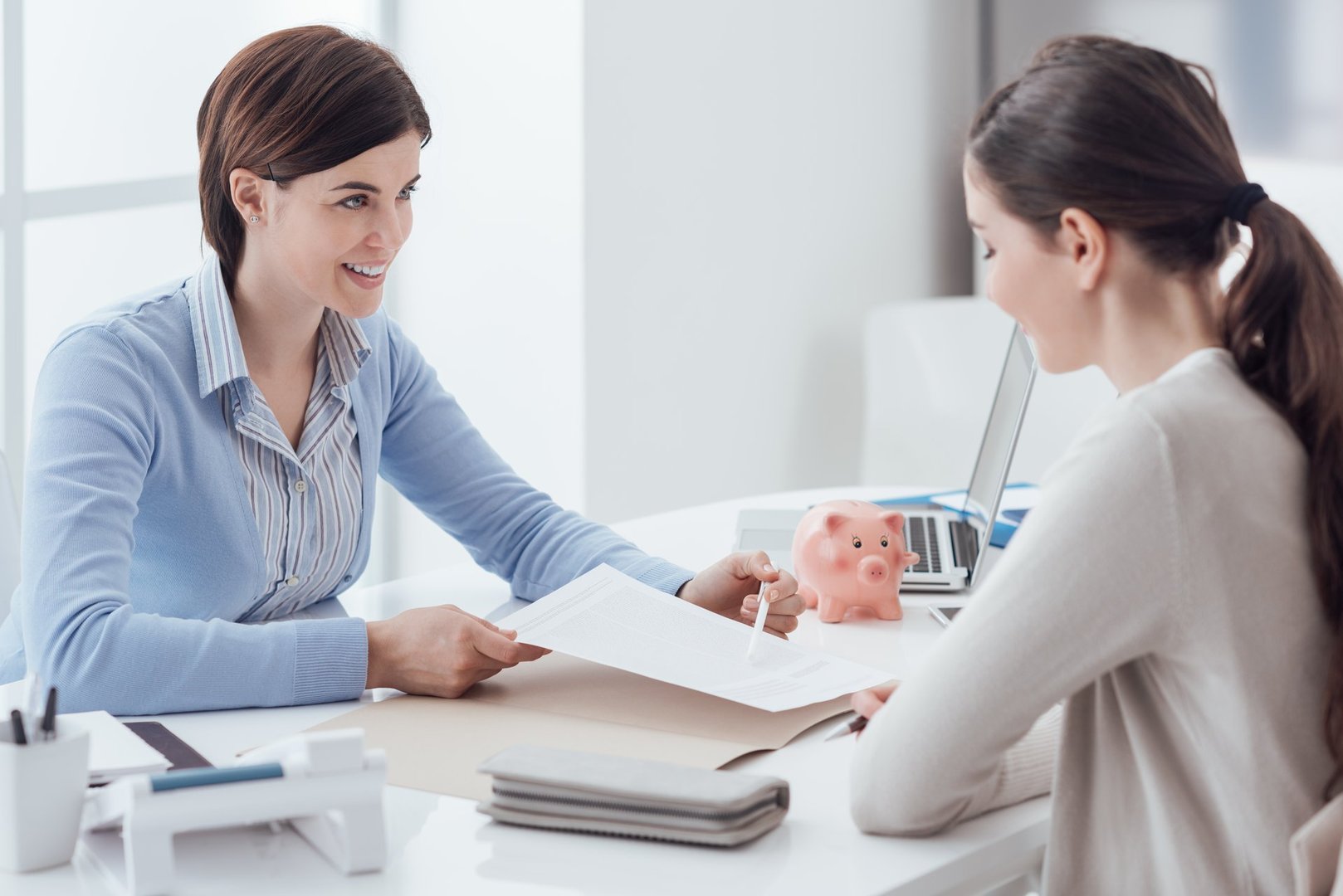 Business consultant and customer meeting in the office, the businesswoman is holding a contract and pointing