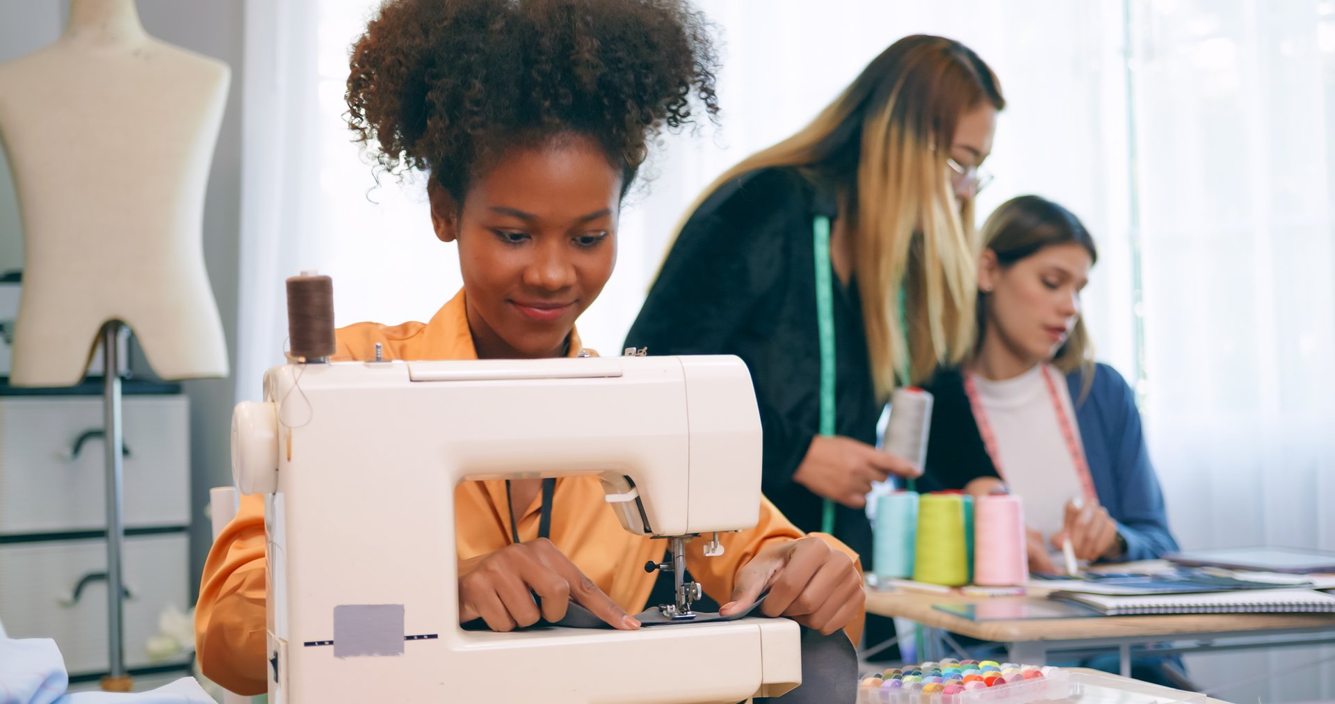 A group of young women are learning the profession of design and tailoring.