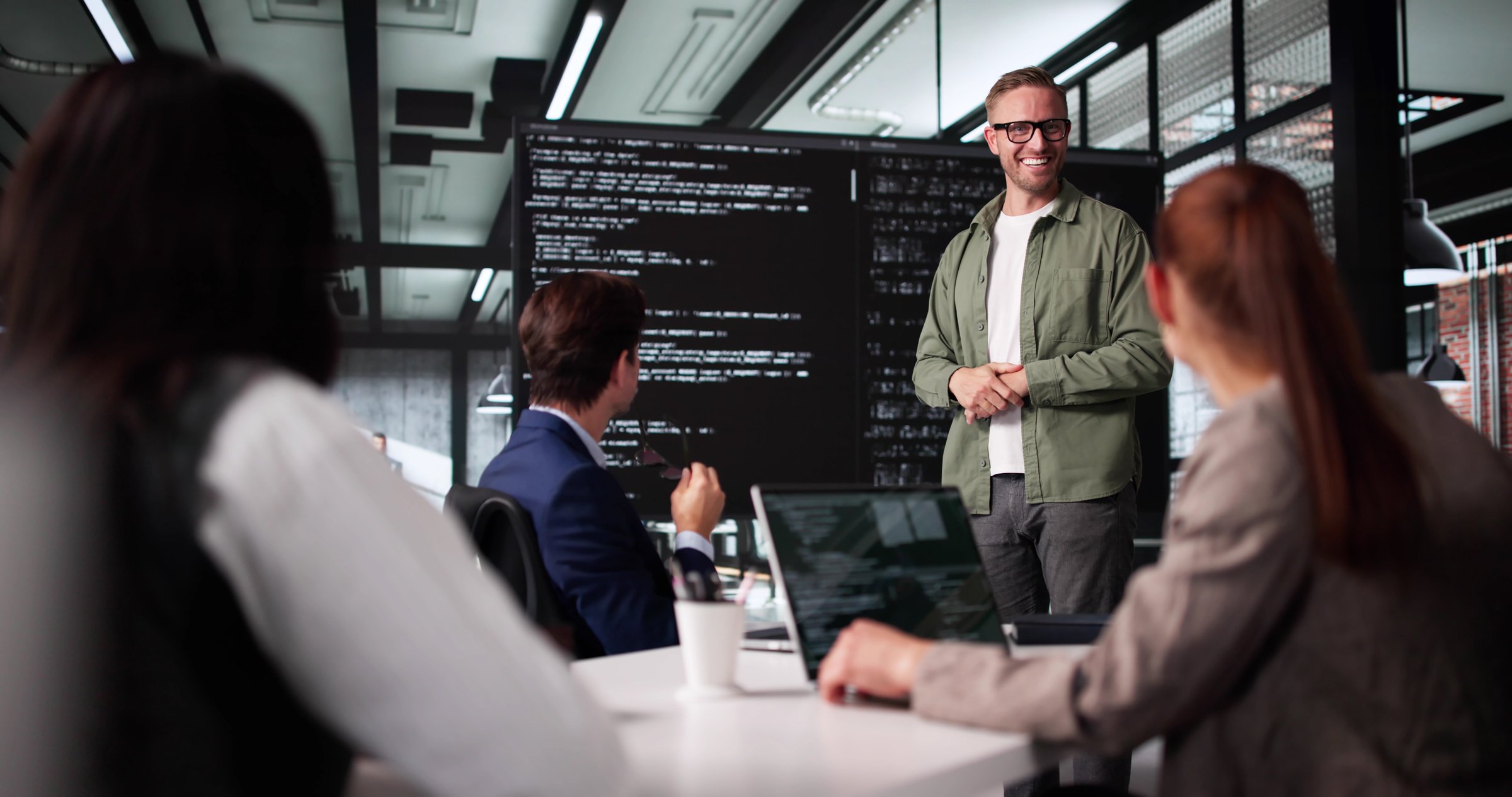 Technician Leading Software Presentation At Business Meeting With Diverse Team.