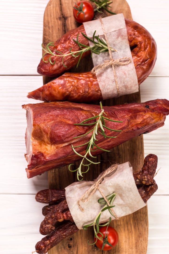 Antipasto catering platter with salami and meat on a wooden background