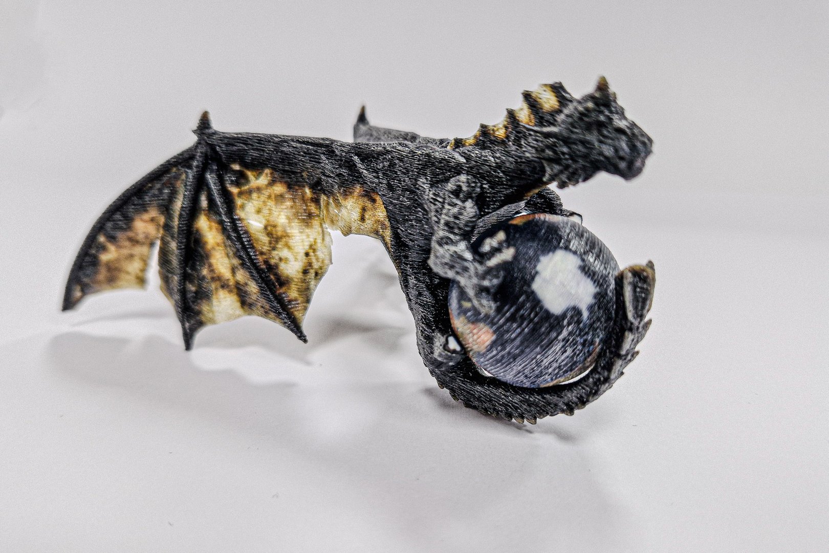 3d printed dragon holding globe