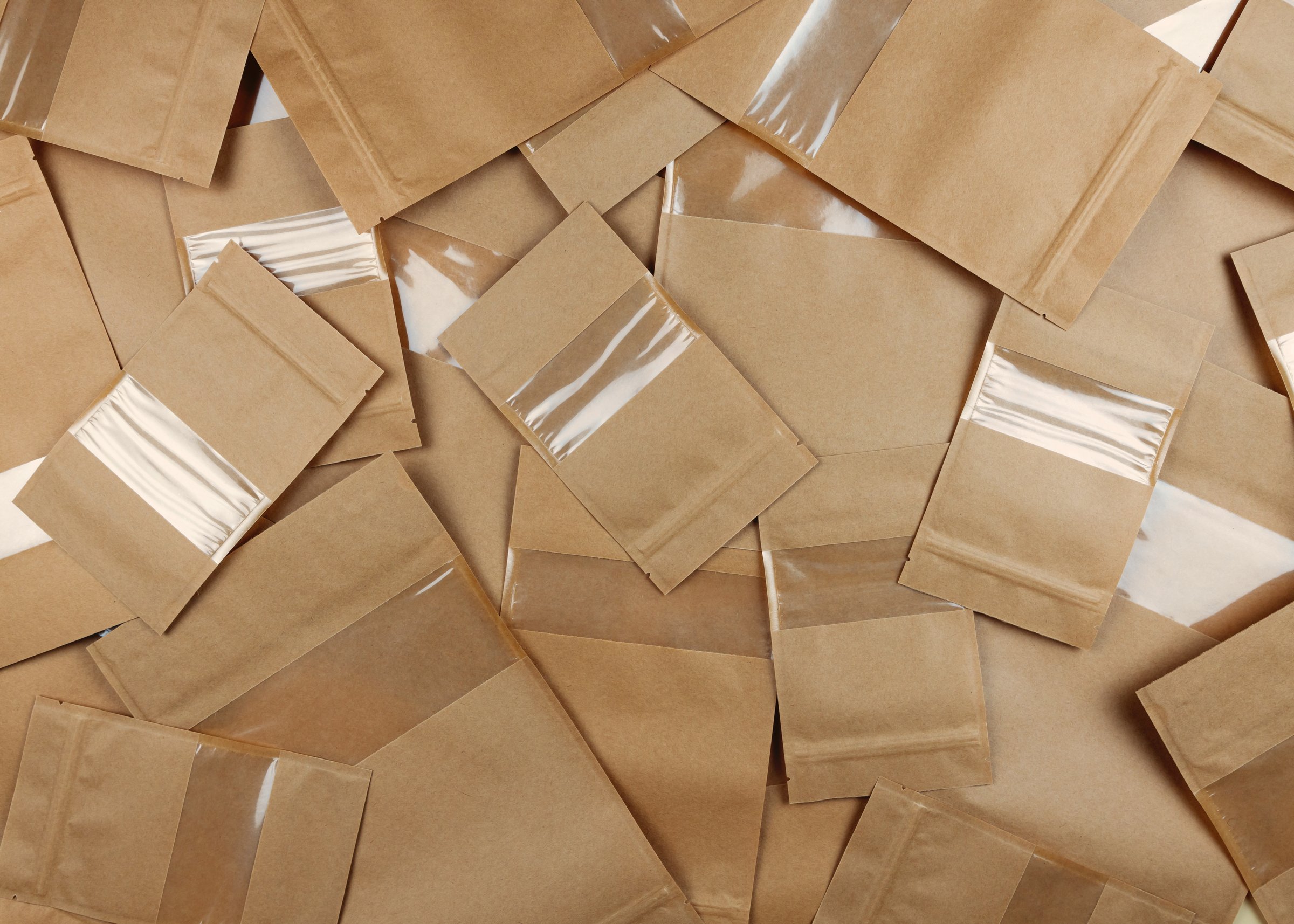 Brown kraft paper doypack bags with groceries front view on a yellow background. Packaging for foods and goods template mock-up. Packs with windows for weight products. Top view