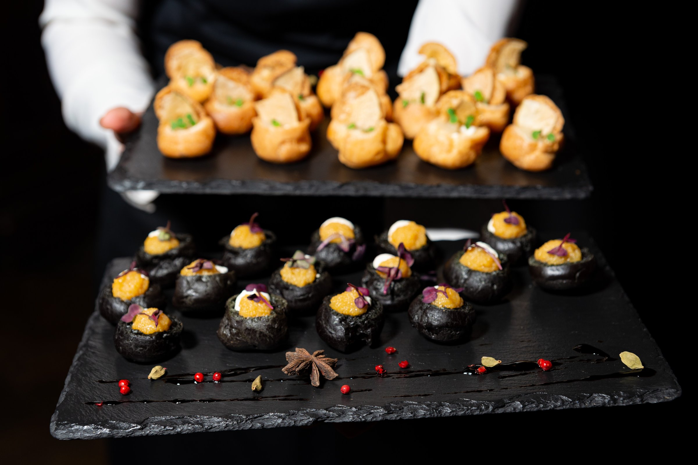 Elegant canapés on black slate trays