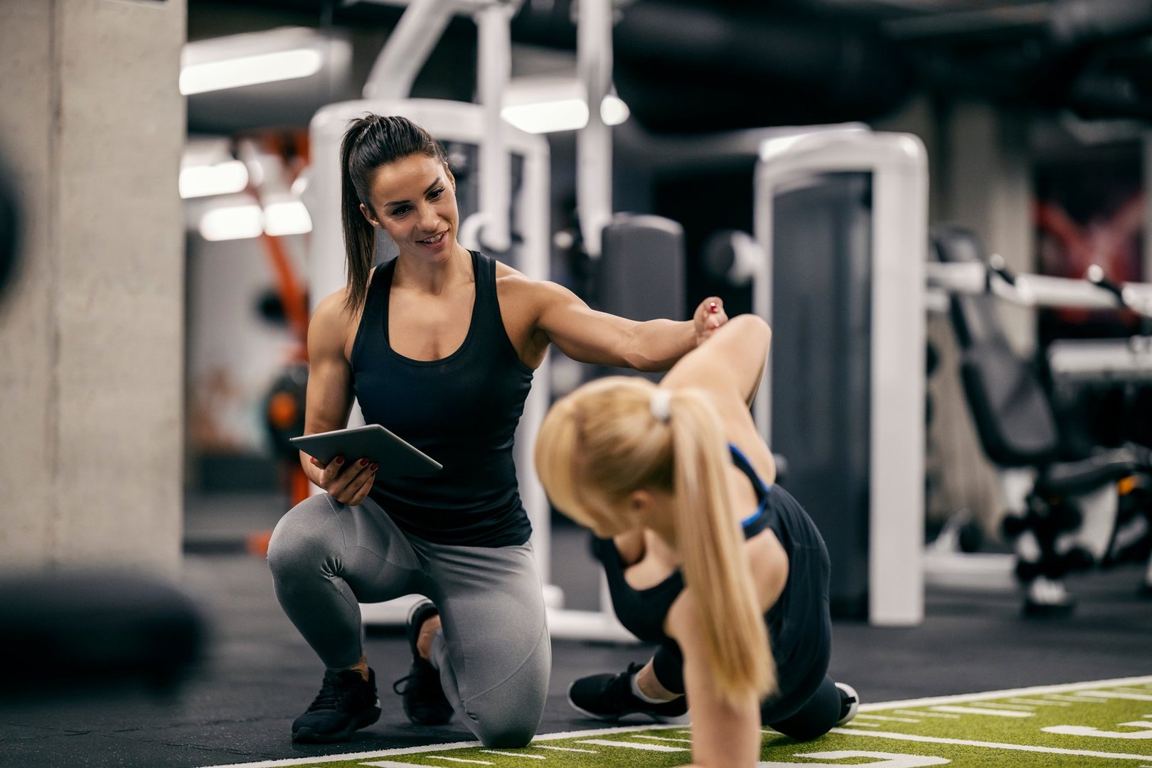 Female personal trainer training client