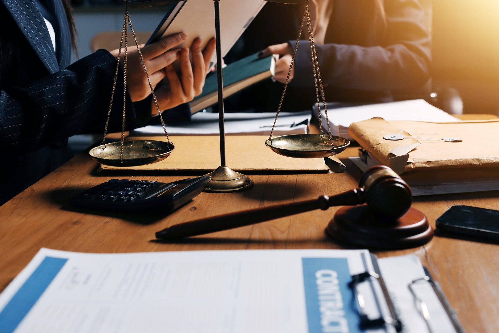 Attractive young lawyer in office Business woman and lawyers discussing contract papers with brass scale on wooden desk in office. Law, legal services, advice, Justice and real estate concept.
