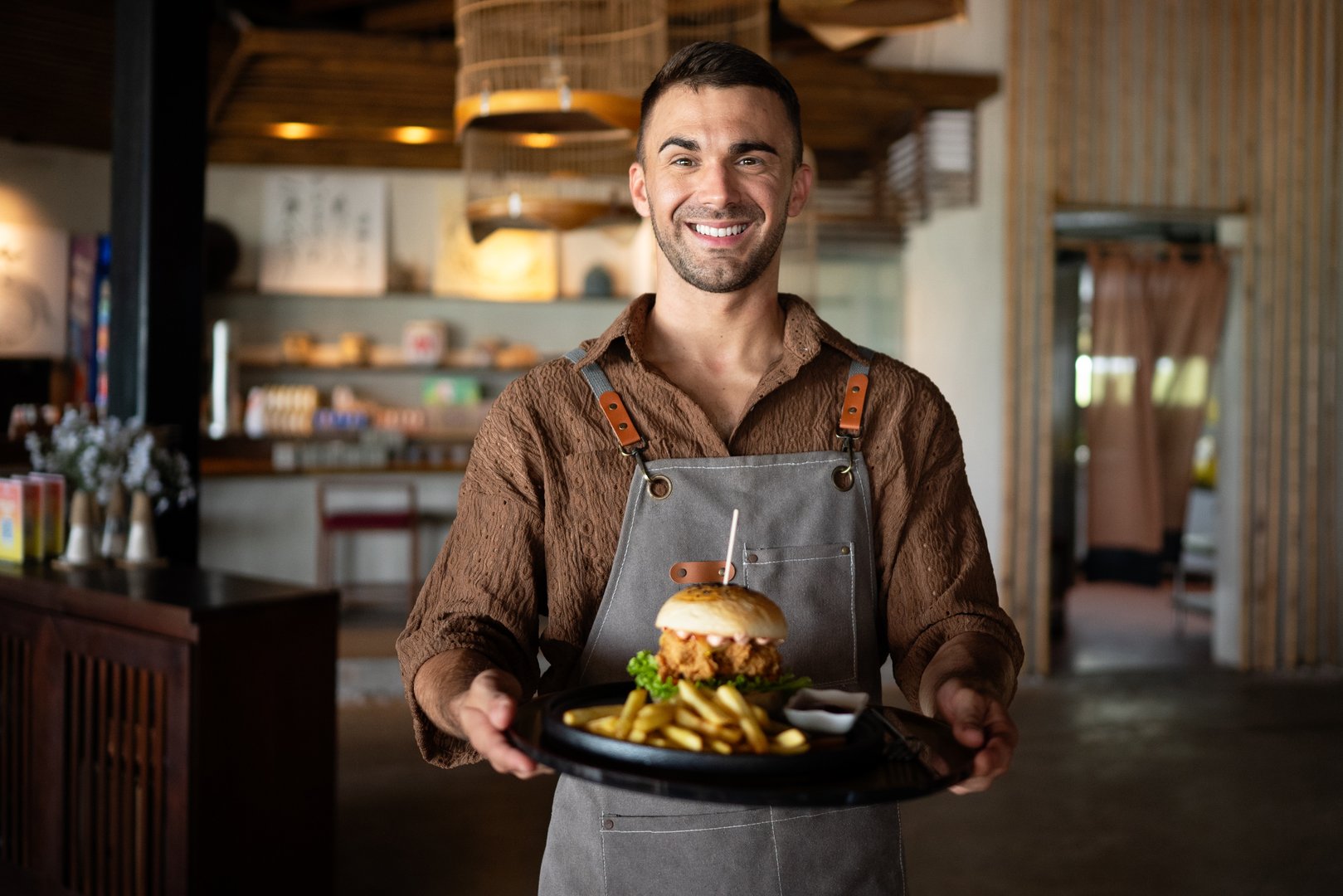 Restaurant marketing moment, a fresh burger and fries served with a smile creates visual content perfect for menus, ads, social media and branding campaigns