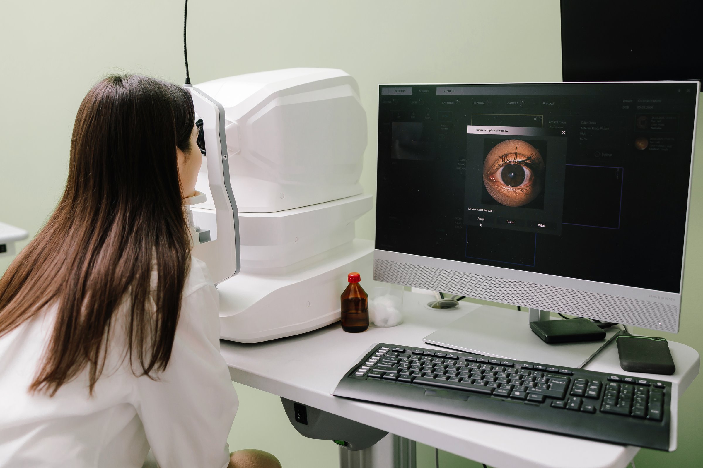 OCT eye scan imaging at an ophthalmology clinic. Girl undergoes a retina exam using optical coherence tomograph. Detailed eye image for diagnosing glaucoma, macular degeneration, and vision issues