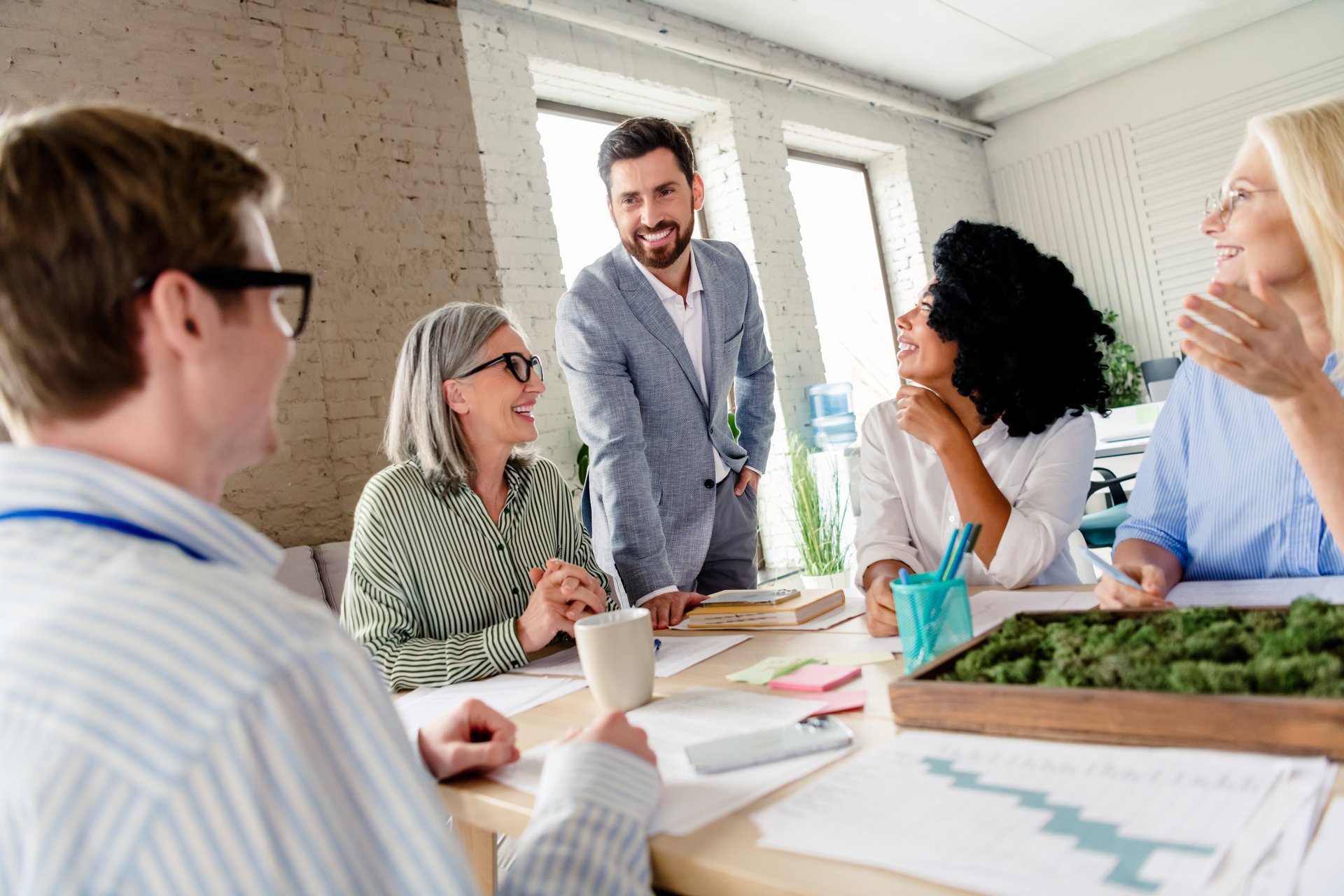 Diverse team working together in an office, sharing ideas and strategies in a cooperative environment during a productive meeting, fostering collaboration, and strengthening professionalism