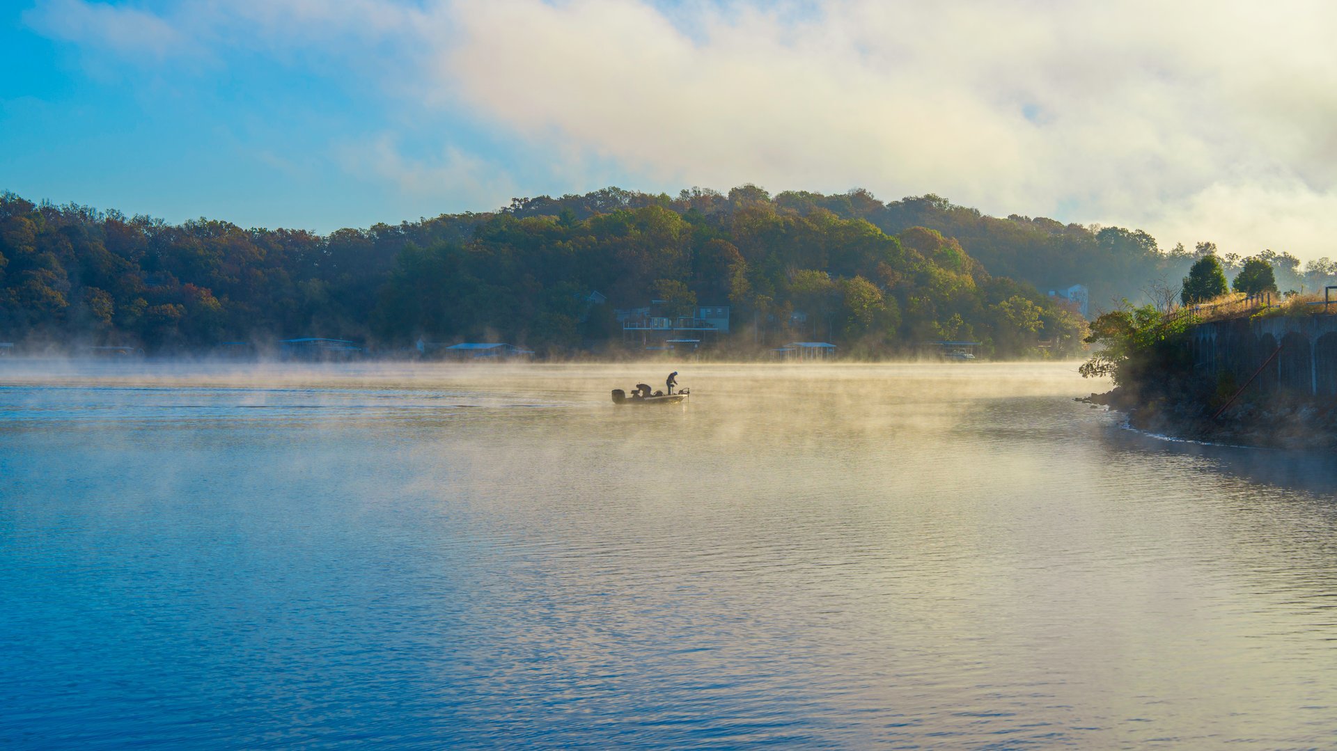 Sunrise with a fishing boat on a Foggy Morning at Lake of the Ozarks in Rocky Mount Missouri, USA