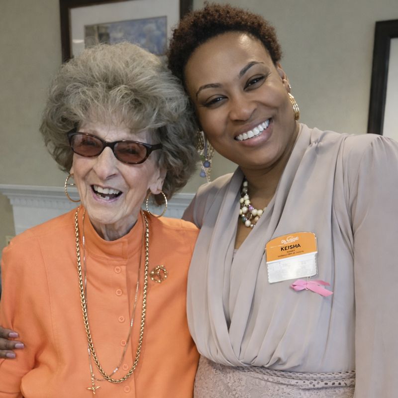 Smiling home nurse posing with happy senior couple, showing positive caregiving