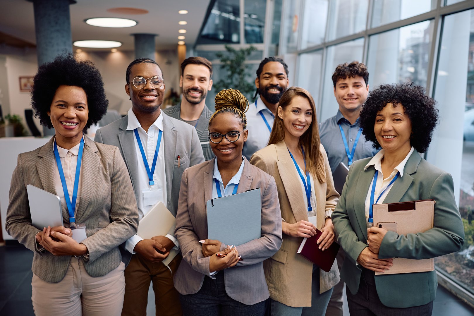Multiracial group of happy business seminar attendees at convention center looking at camera.