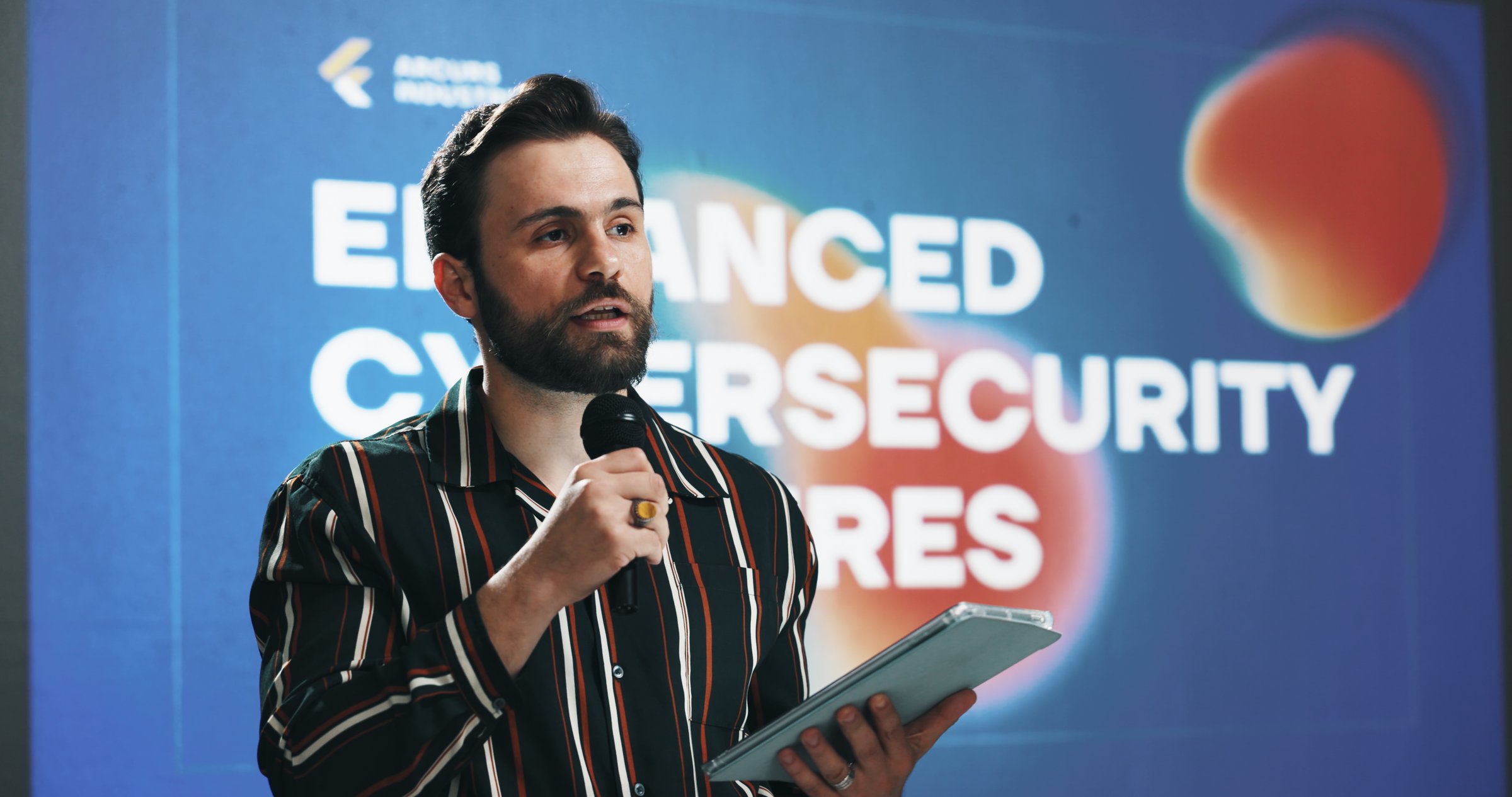 Businessman, tablet and presentation with mic for seminar or cybersecurity convention at workplace. Man, speaker or presenter talking with technology for online safety measures or awareness campaign