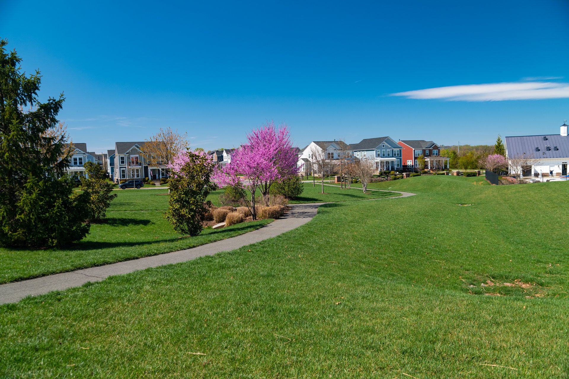 walking path and green lawn with gazebo in residential community.