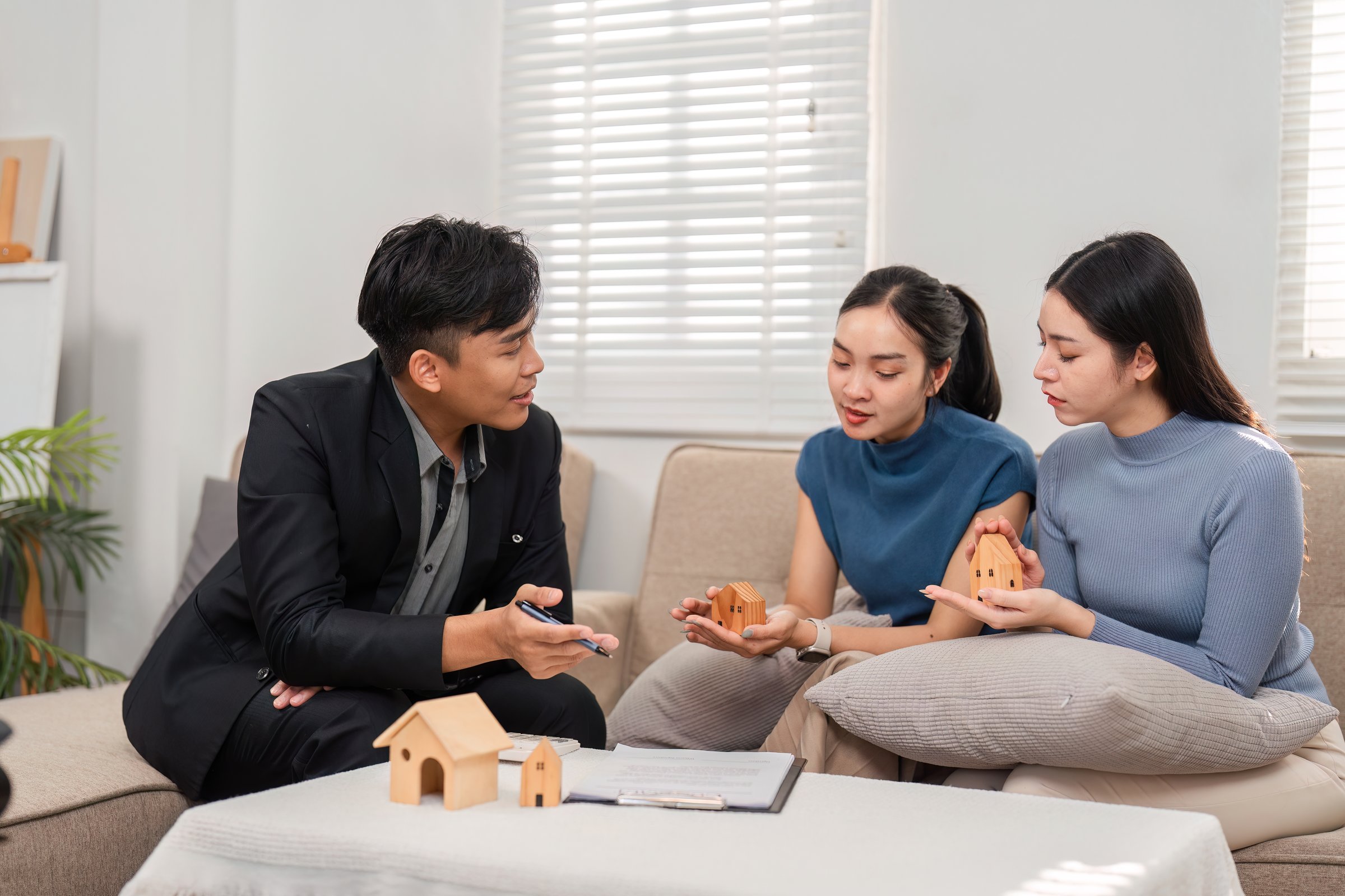 An engaged real estate agent shares insights about housing options with two clients, fostering a positive and collaborative atmosphere.