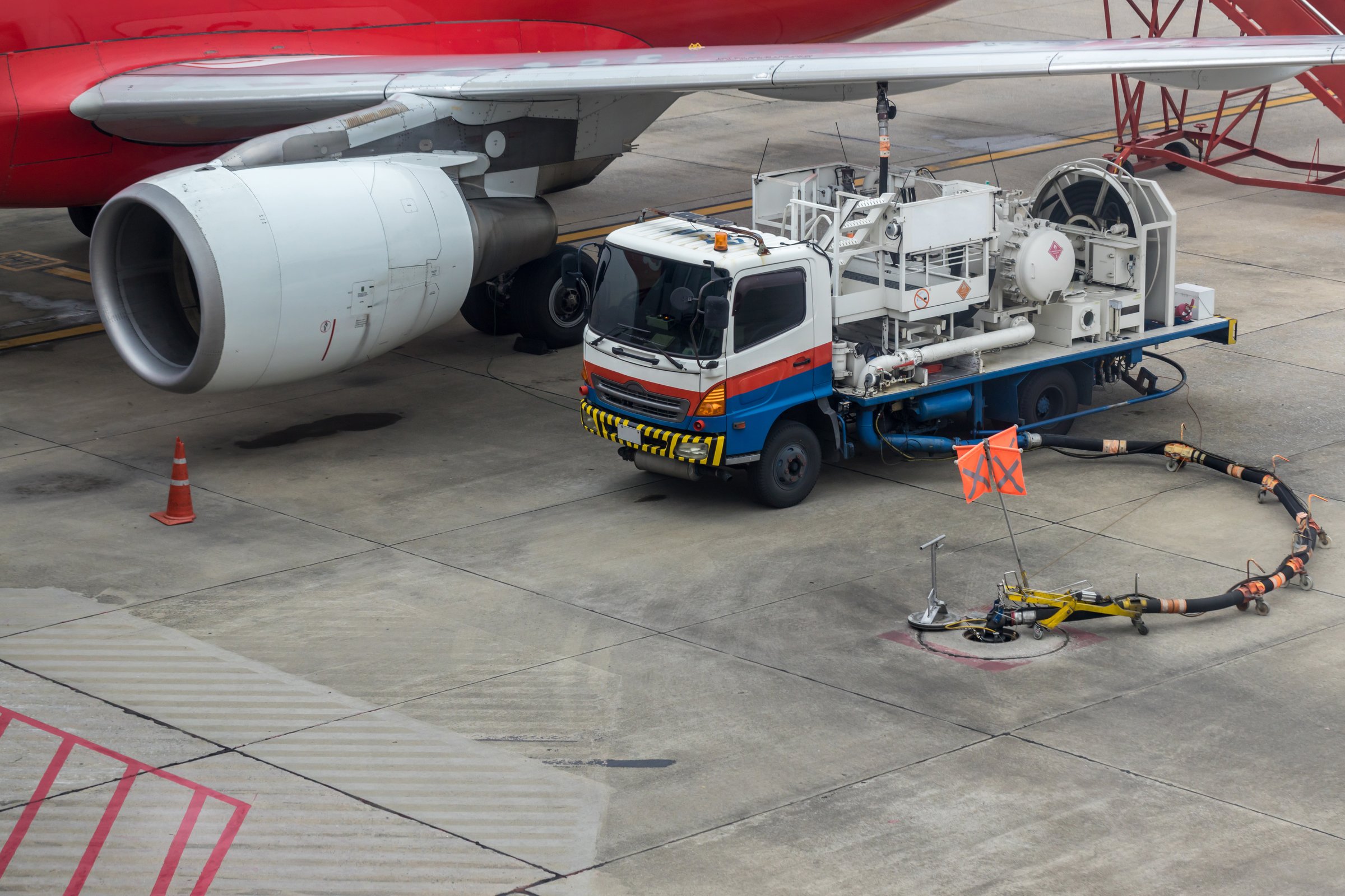 Aircraft refueling by high pressure fuel supply truck. Refueling operation of large widebody passenger aircraft standing on airport's parking place . Refueling of the airplane before flight.
