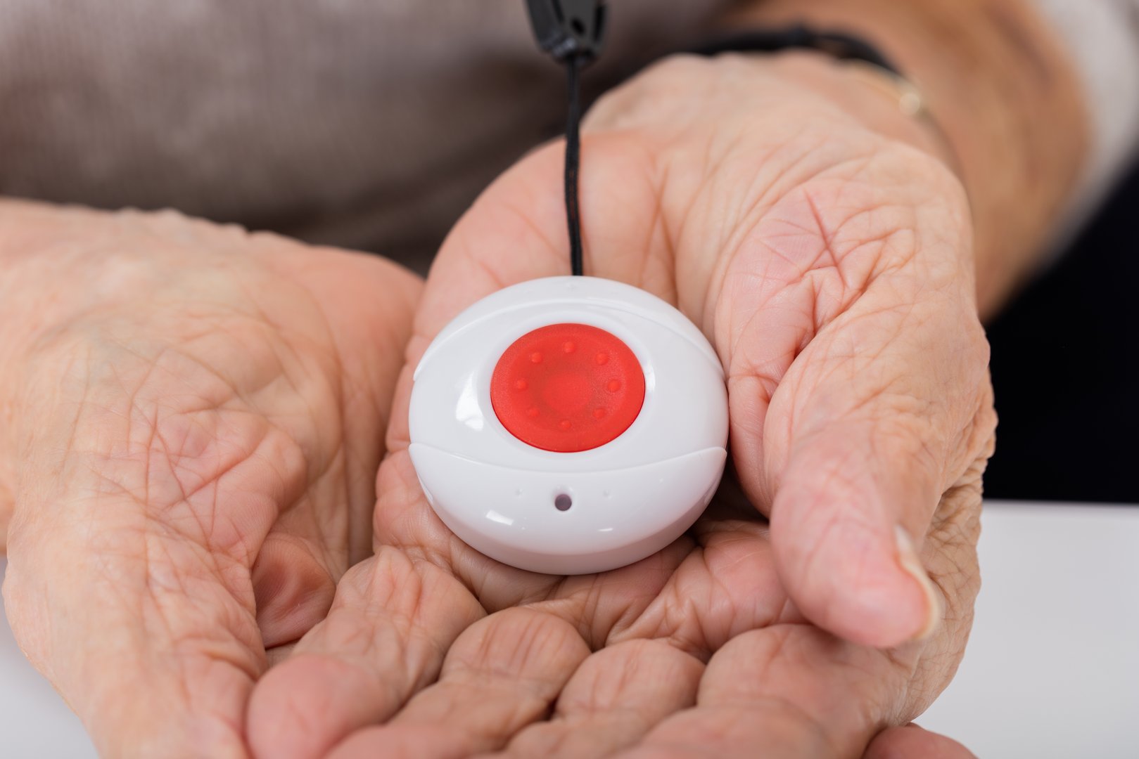 Close-up Of Senior Woman Holding Alarm Button For Emergency