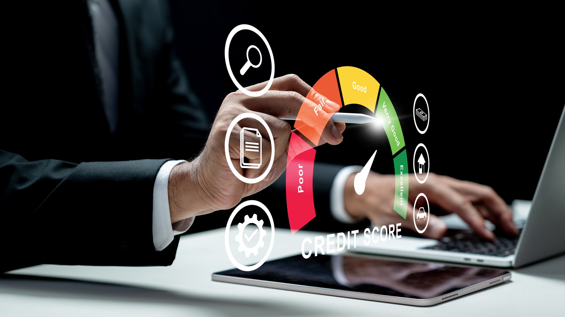 Businessman using a laptop while touching the icon of his credit score on the tablet screen. Technology innovation on a virtual screen. Concept of credit score