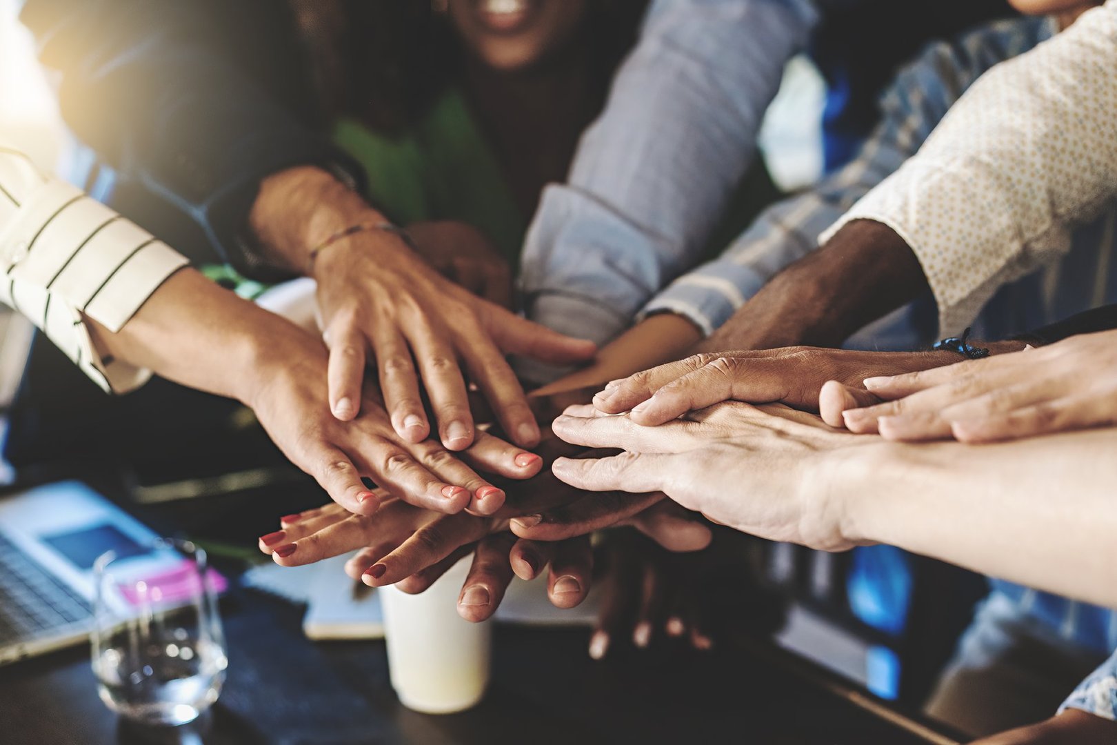 Multiracial group of businesspeople joining hands in stack - cooperation, diversity, unity, success and team building business lifestyle concept
