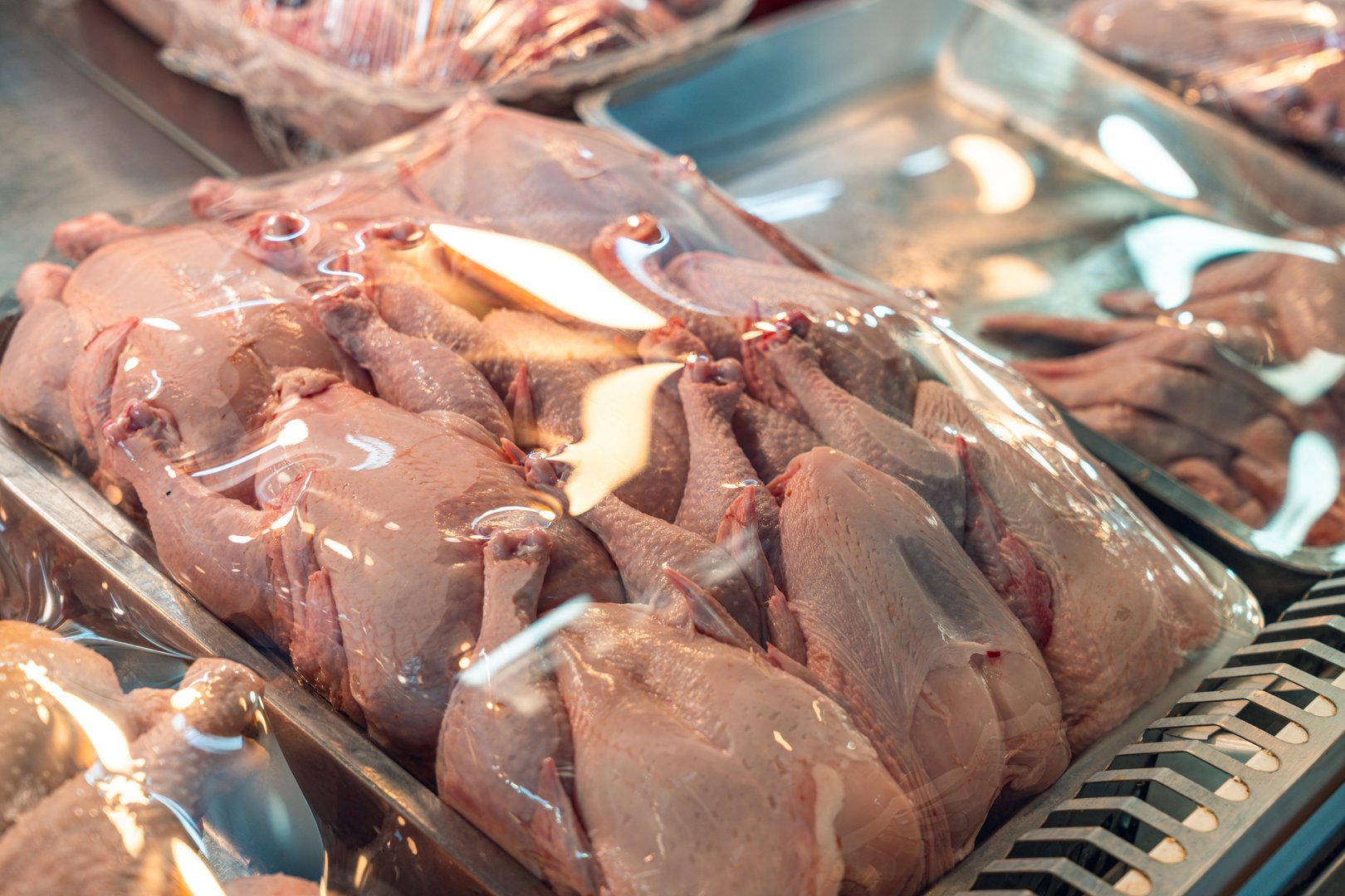 Fresh poultry packaged and displayed in a meat case, highlighting the quality and presentation of the product in a market setting.