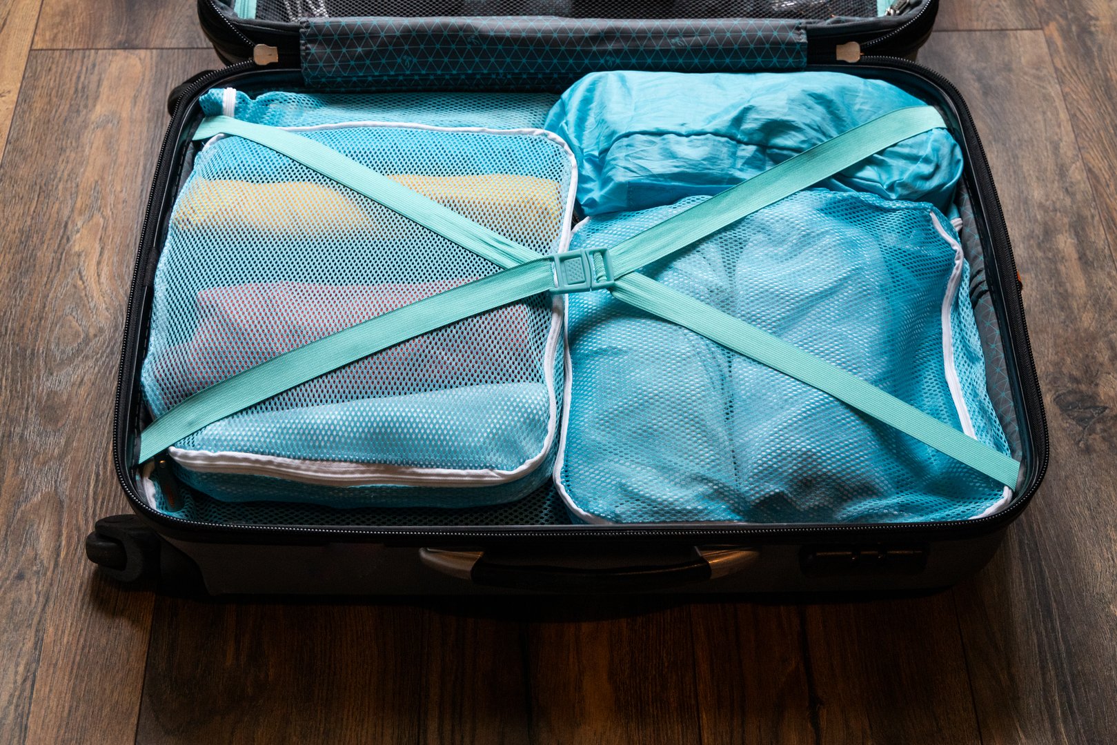 Clothes rolled and packed in small bags in suitcase to organize and save space during vacation travel