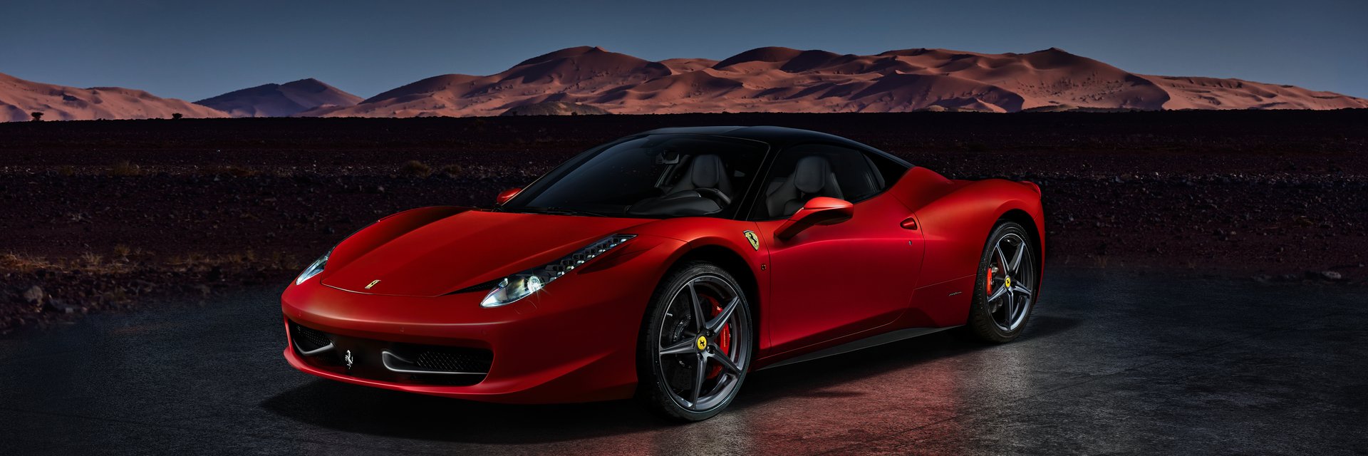 A red Ferrari 458 Italia standing in front of the desert dunes. Engine V8, 4.5L, 570HP. Electronic assembly with Moroccan landscape. Katowice, Poland, 23/12/2013