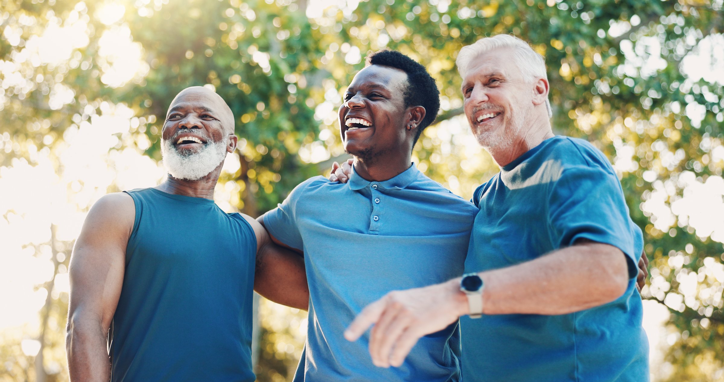 Senior, men and laughing for fitness outdoor of mobility training, funny discussion and morning routine. Below, people and coach with embrace of conversation, exercise joke and cardio workout at park