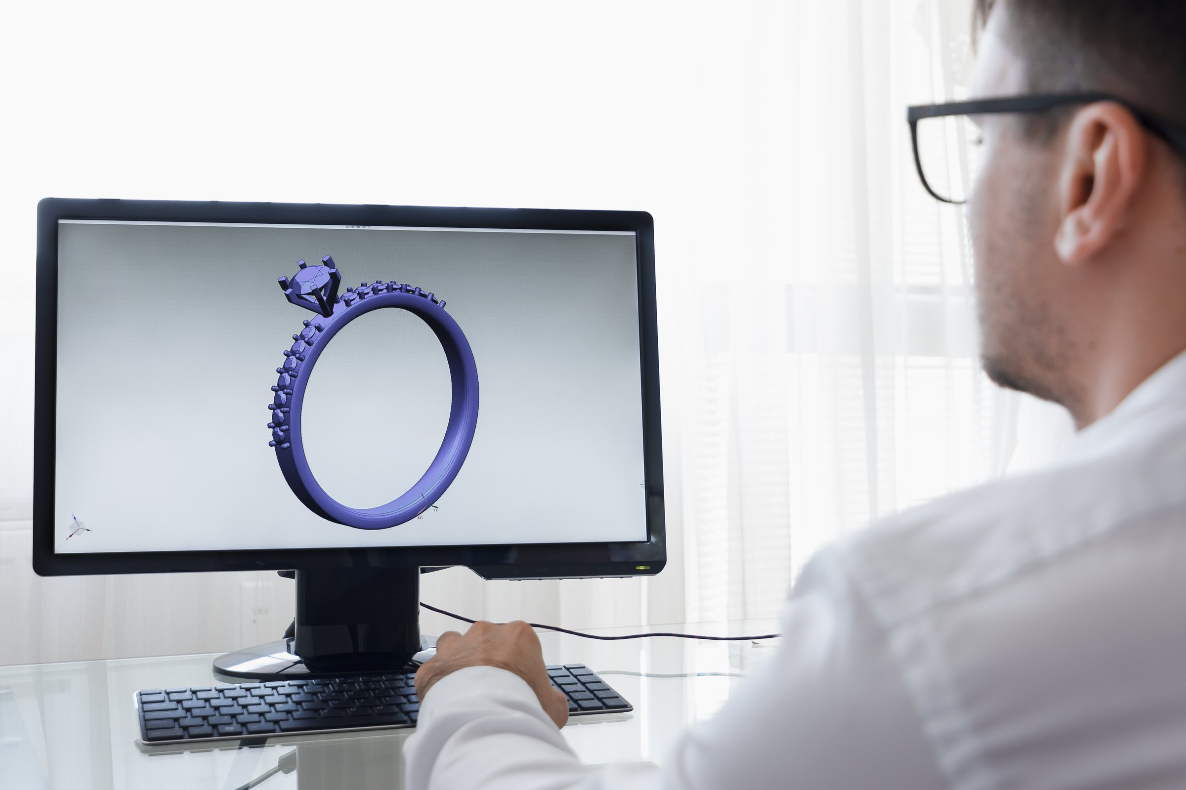 LOS ANGELES, CALIFORNIA - JUNE 3, 2019: Engineer, Constructor, Designer, Architect in Glasses Working on a Personal Computer. He Creating New Design of Golden Ring in CAD Program. Freelance Work. An illustrative editorial image.