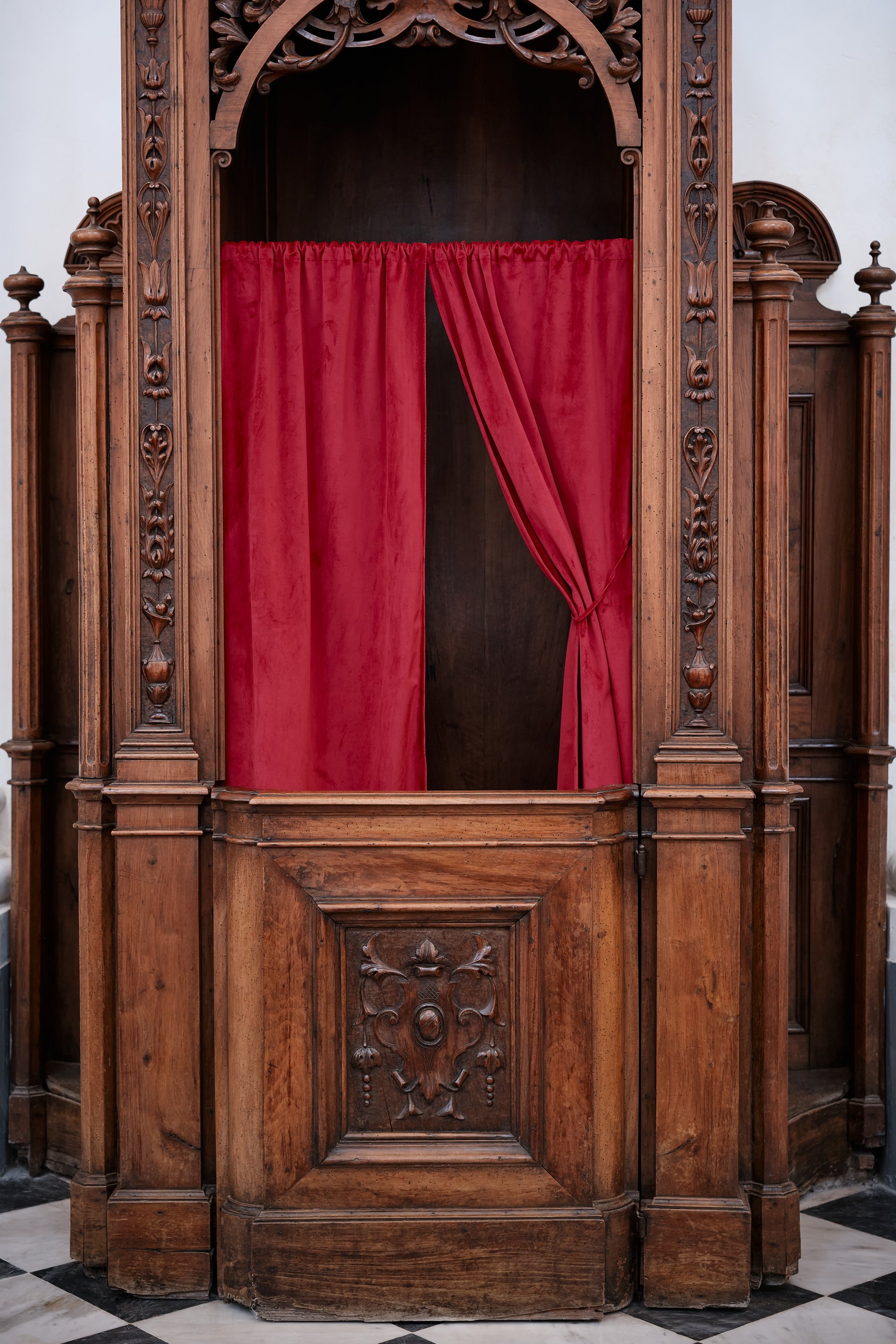 Old wooden confessional inside church, symbolizing confession, forgiveness, and spirituality in Christian tradition.