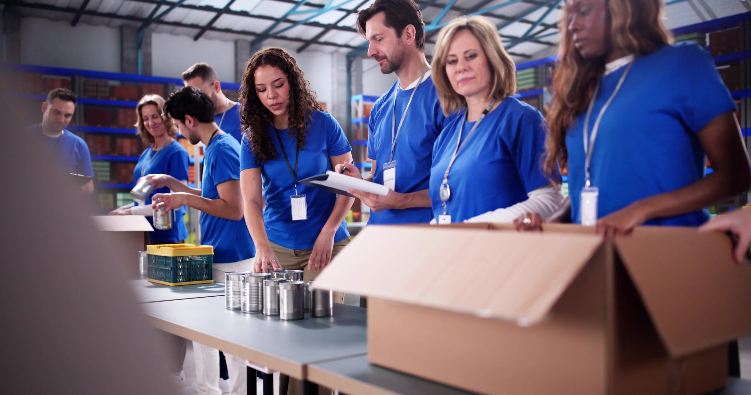 Diverse Group of Volunteers Organizing Food Bank Donation Boxes Today.