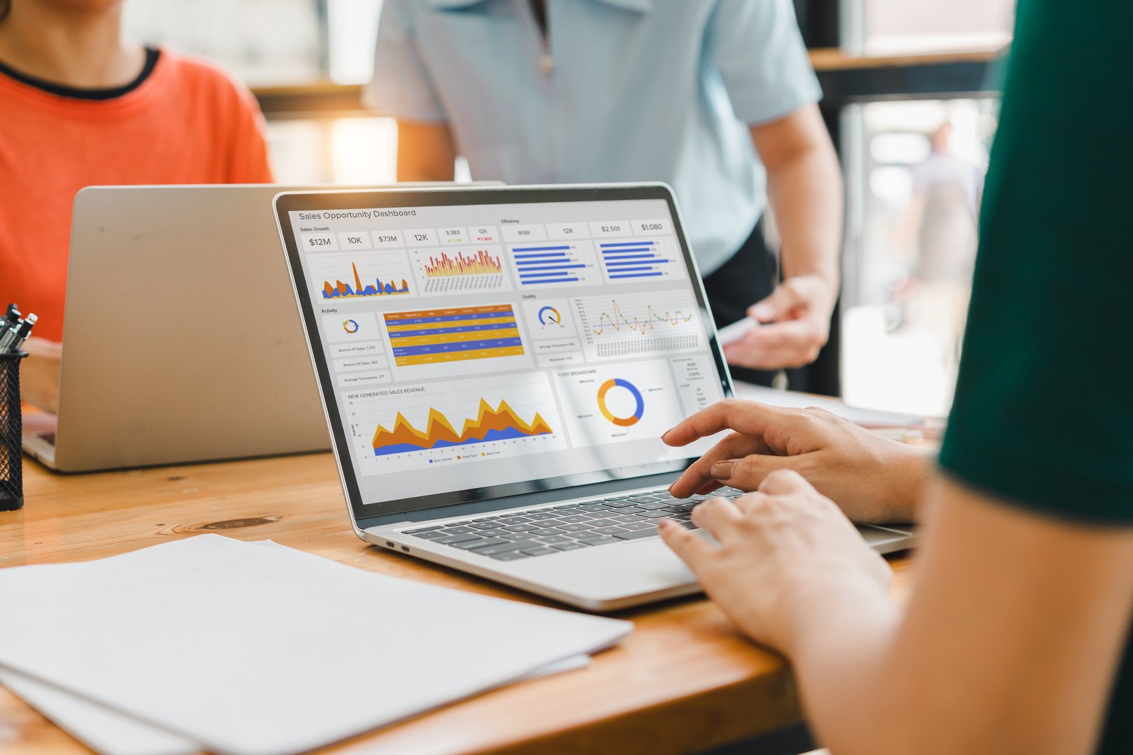 A person interacts with a digital sales dashboard displaying various performance metrics and analytics.