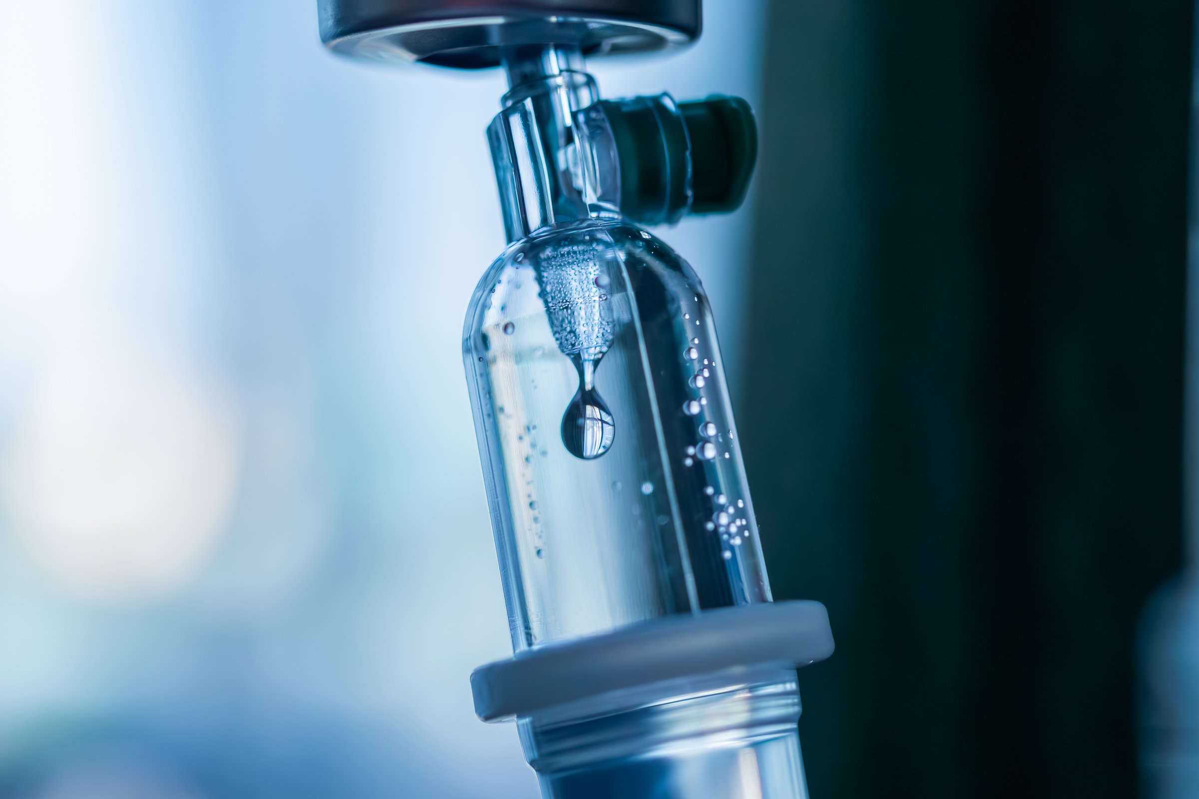 Close up medical intravenous IV drip in hospital background
