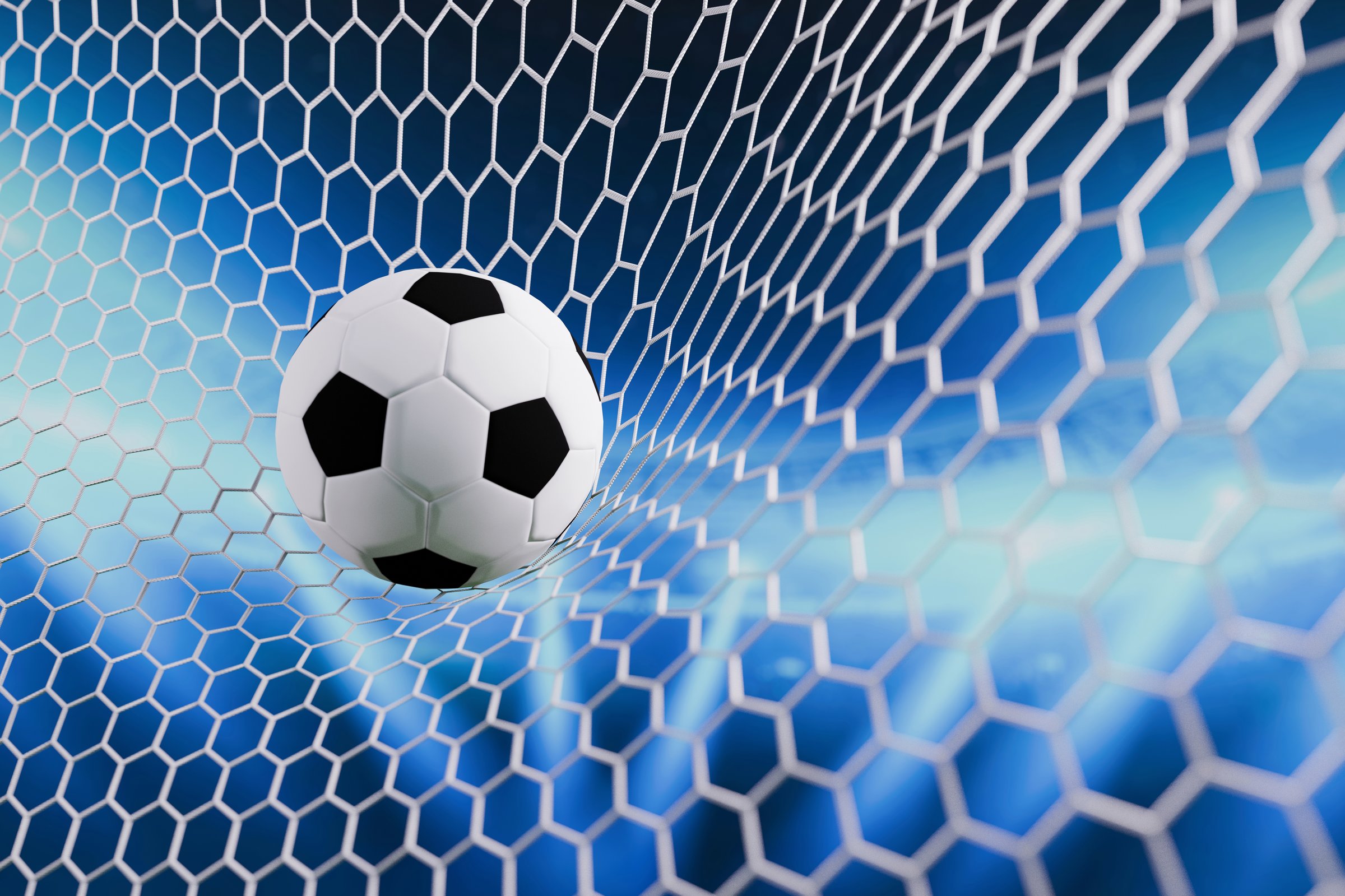 Football goal moment with ball in net, illuminated by bright lights, symbolizing achievement, teamwork, and sports victory. Soccer ball in the goal, goal scored. Football